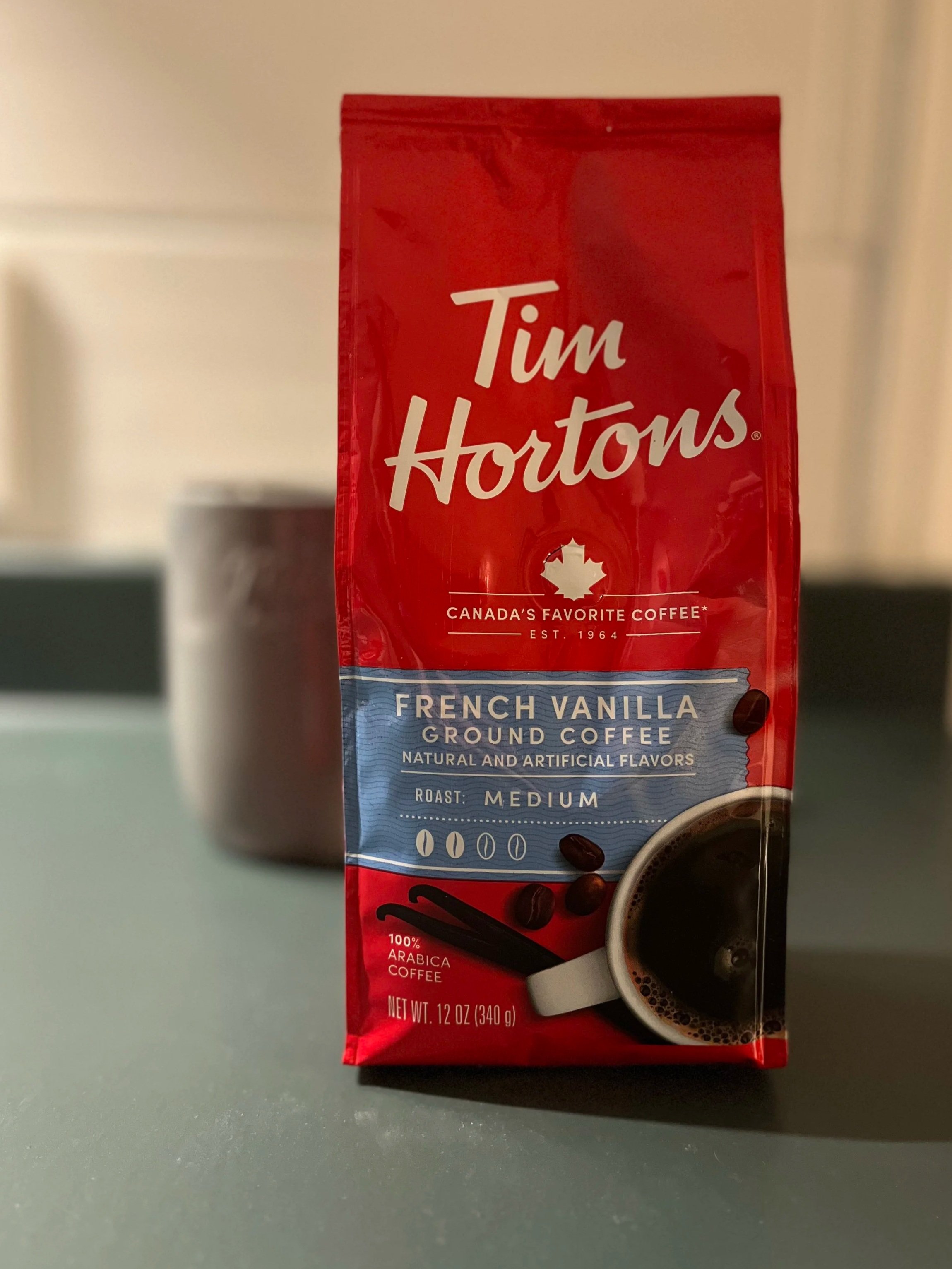 coffee mug next to a bag of coffee from Tim Horton's
