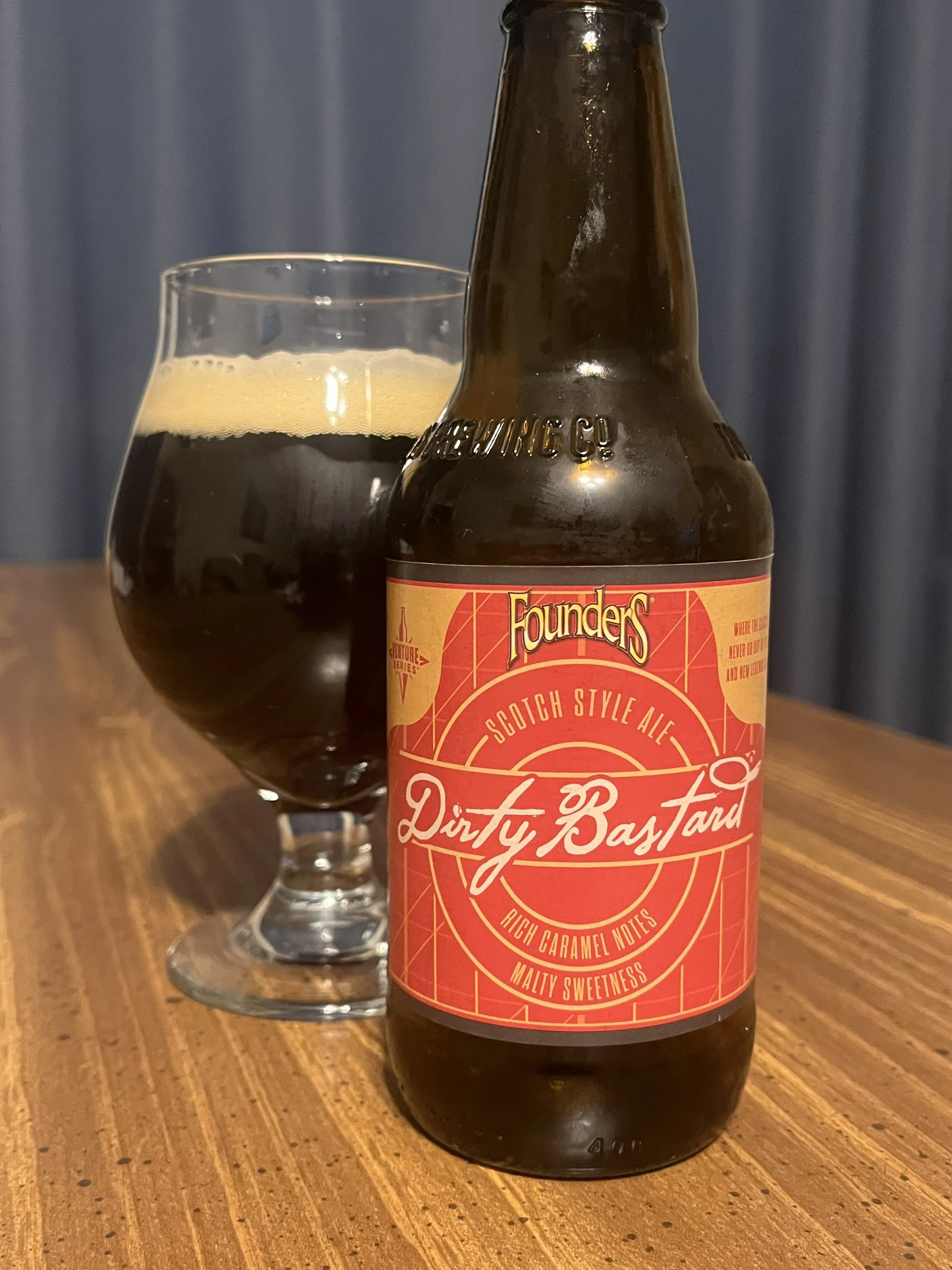 tulip glass next to bottle of Founders' Dirty Bastard beer