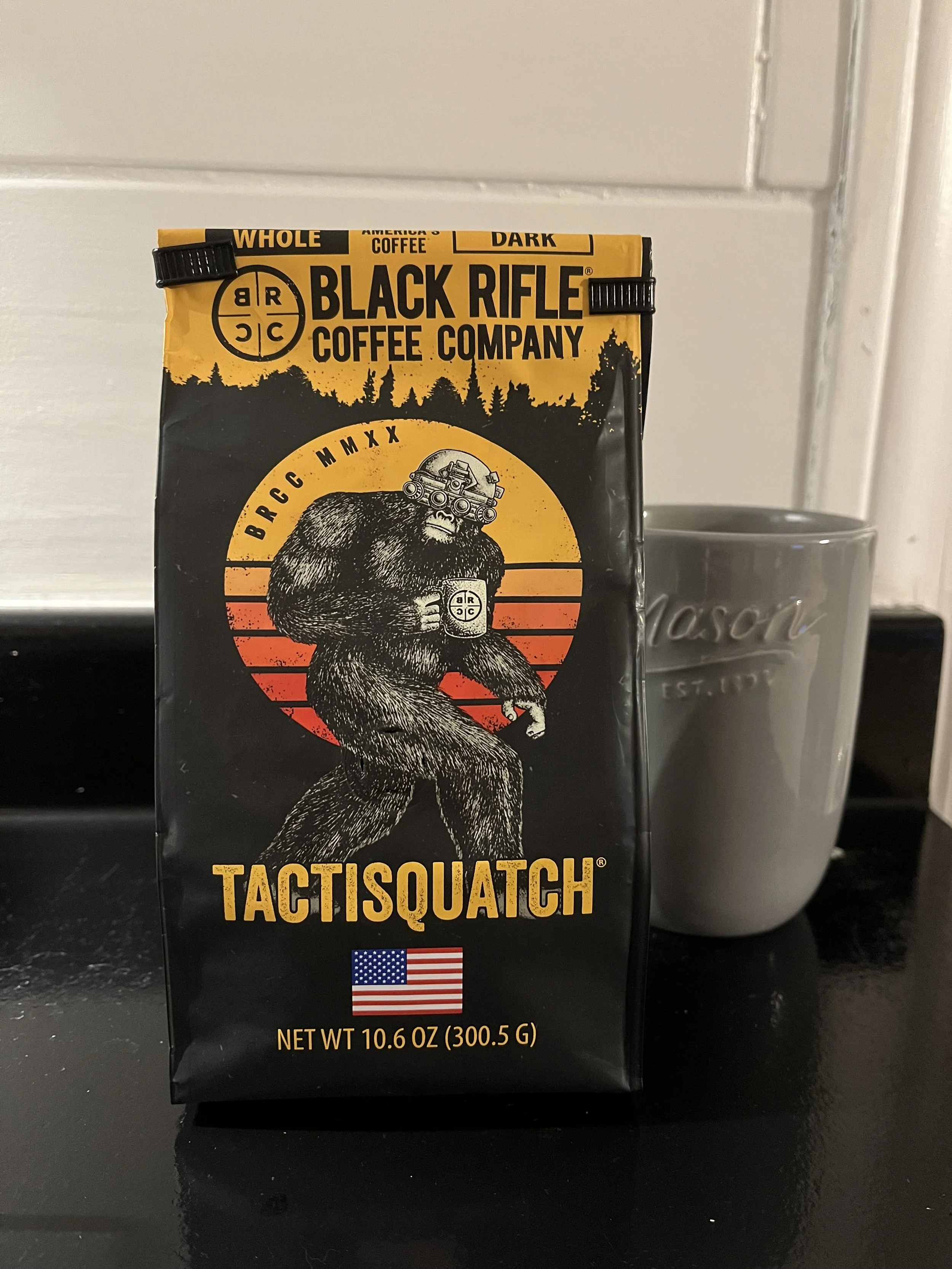 bag of coffee beans next to coffee mug