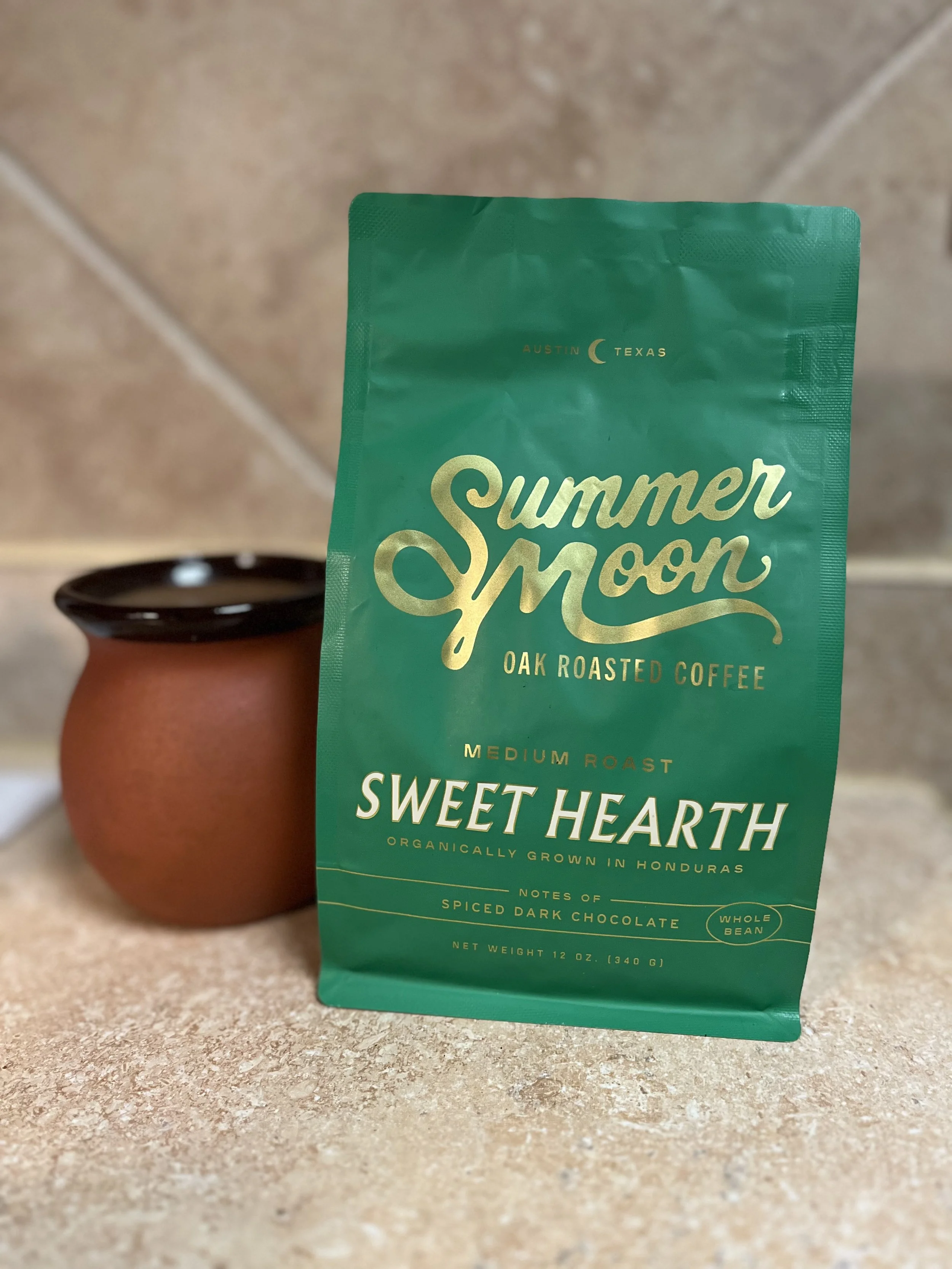 coffee cup next to bag of Summer Moon beans