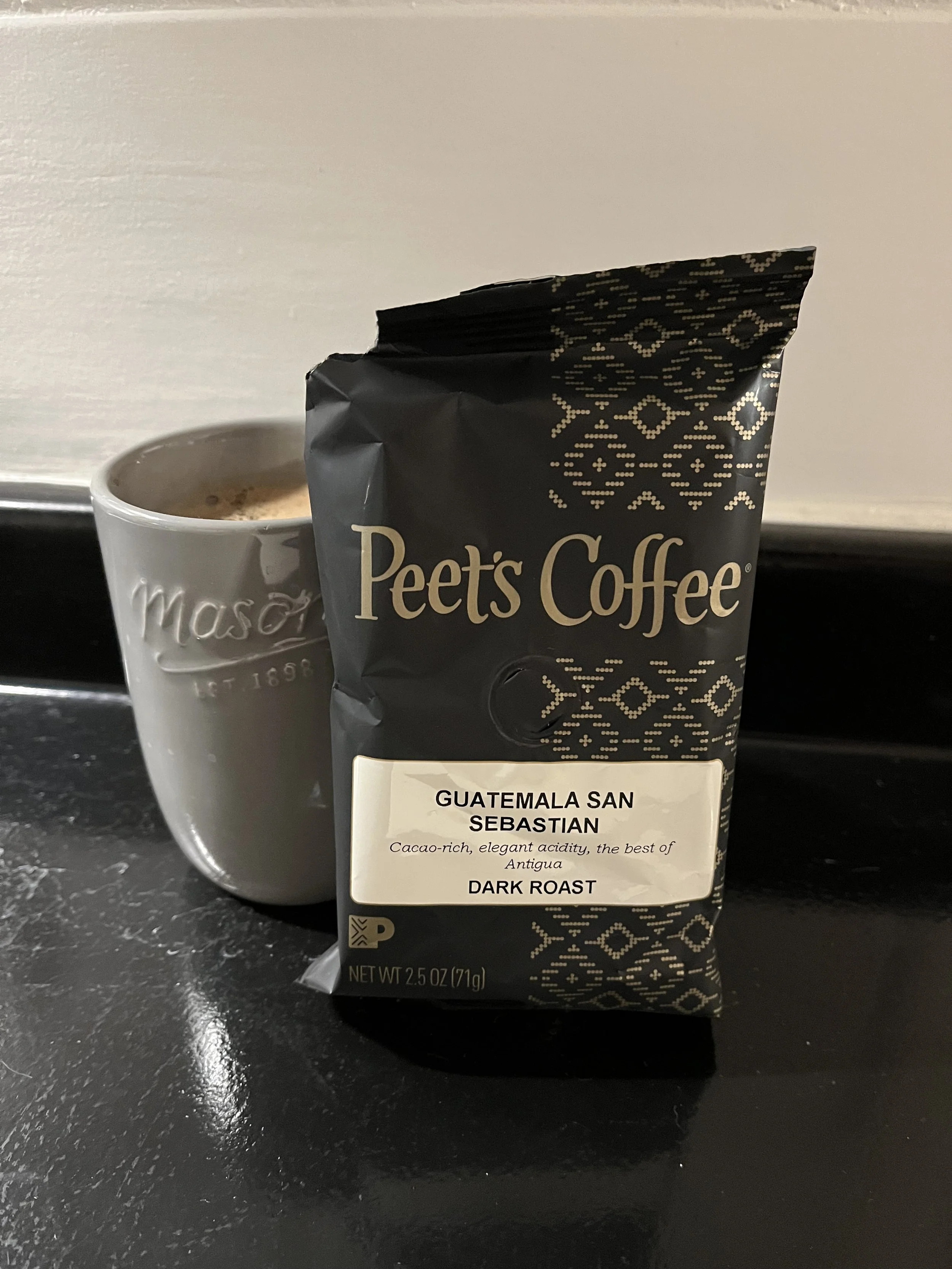 coffee mug next to bag of Peet's coffee