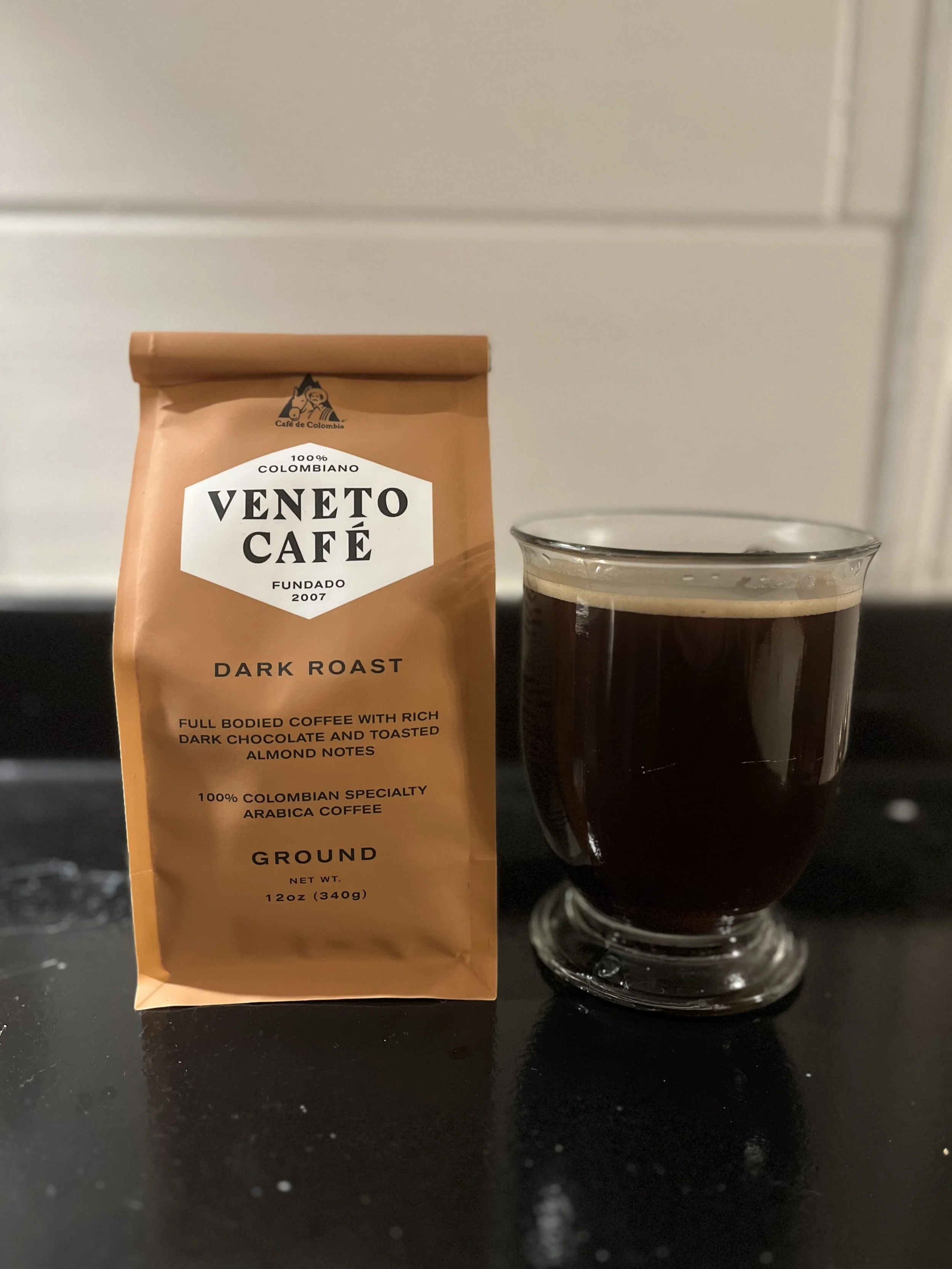 bag of Veneto Cafe coffee grounds next to glass mug of coffee
