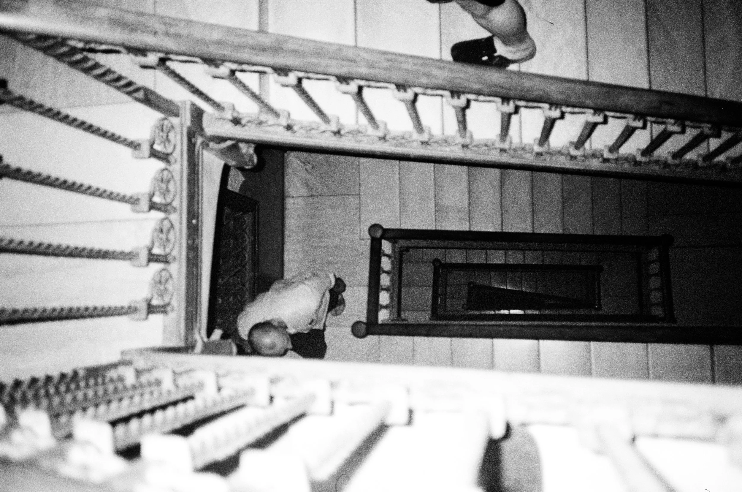 Black and white photo taken from above showing a staircase with several steps and a few children walking down it.
