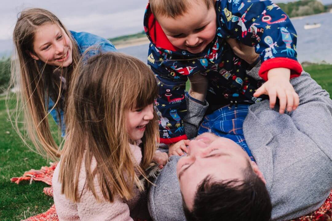 children playing with father on floor Rutland Water family photography