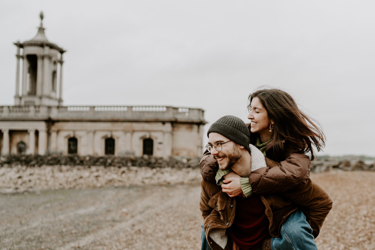 couple piggy back Rutland water pre-wedding photoshoot