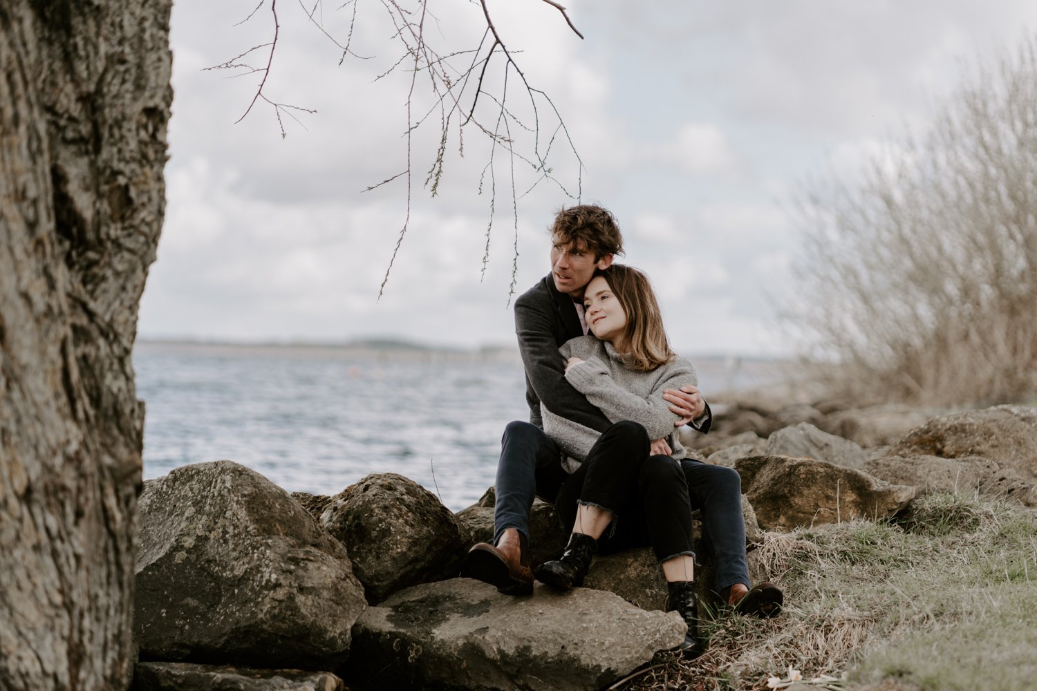 couple seated embracing Rutland Water pre-wedding photoshoots