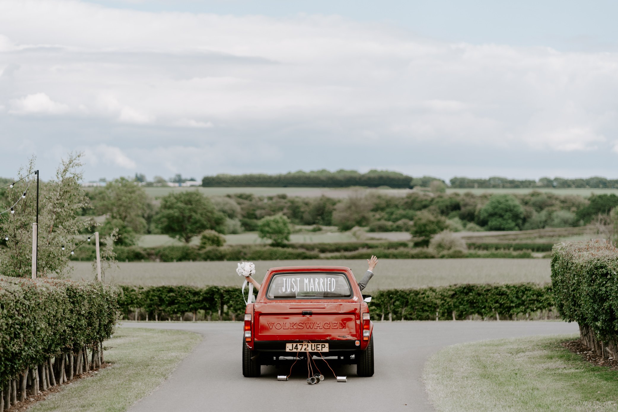 bride groom leaving just married sign vintage red VW relaxed barn wedding Leicestershire