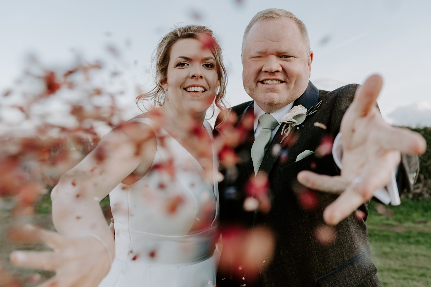 bride groom throwing confetti at camera Halfmoon Farm wedding hambleton
