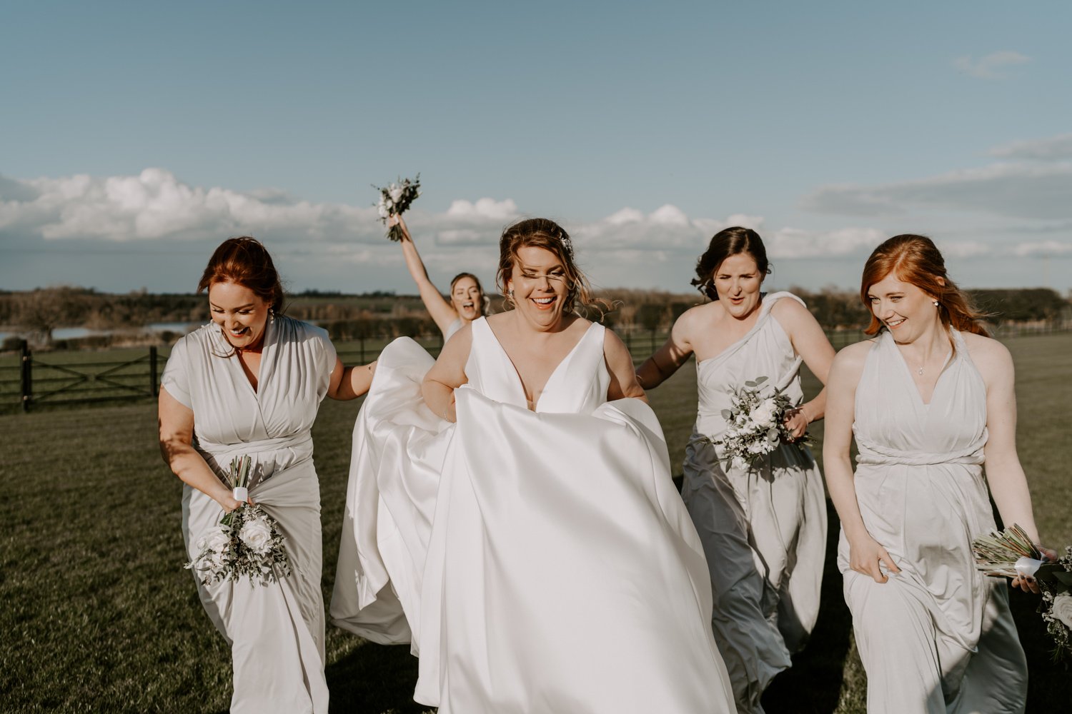bride and bridesmaids walking laughing Halfmoon farm wedding Hambleton