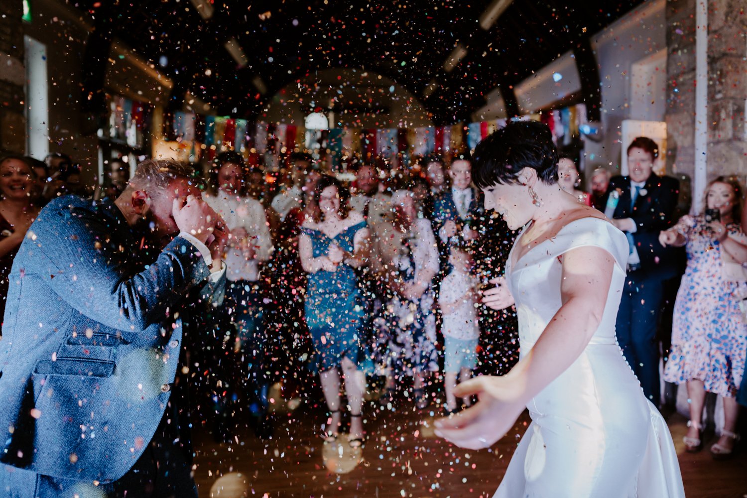 bride groom dancing on dance floor amongst colourful confetti mardi gras village hall wedding Castor Peterborough