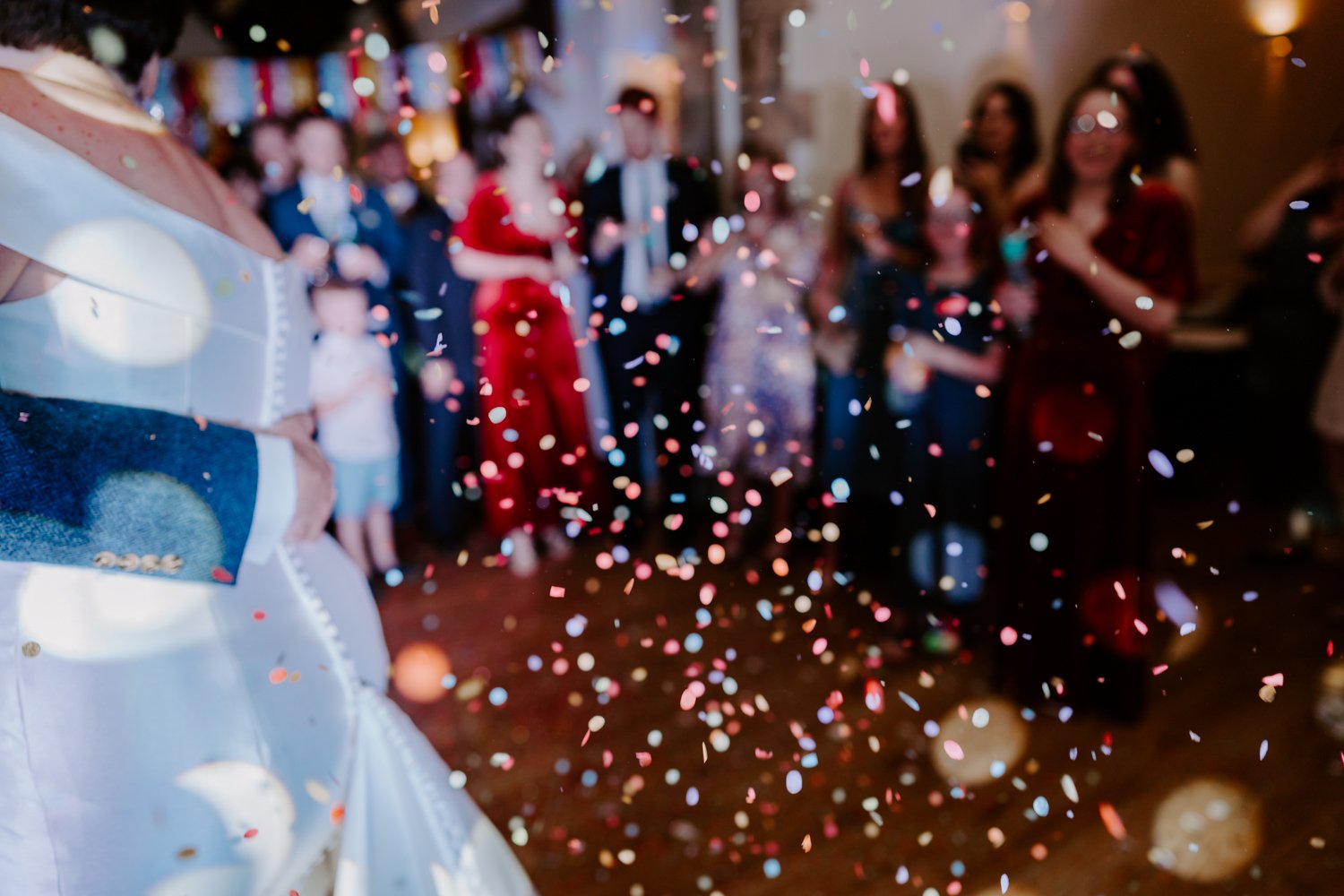 colourful confetti on dancefloor wedding first dance bride groom dancing mardi gras village hall wedding Peterborough