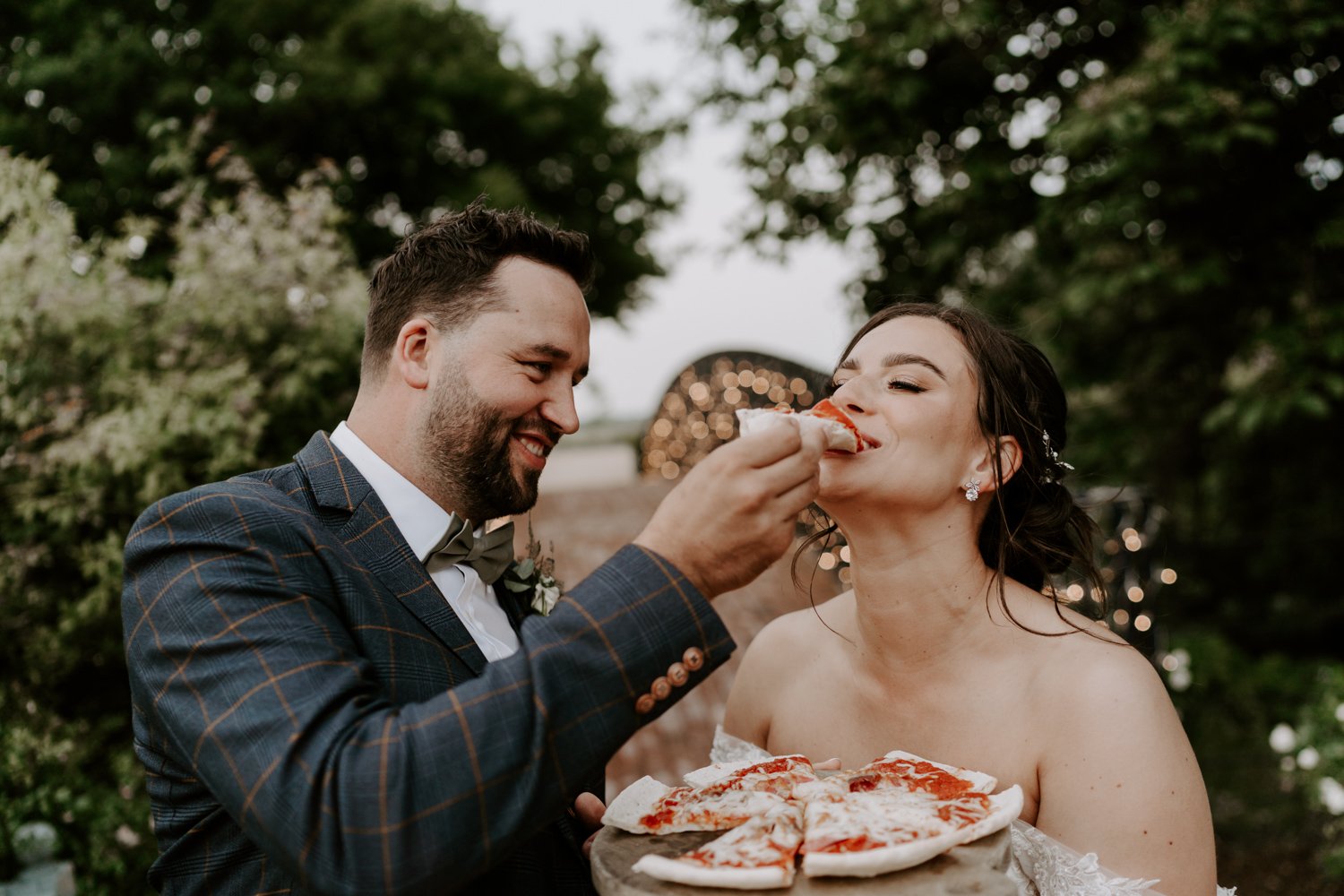 groom feeding bride woodfired pizza Bassmead Manor Barns wedding 