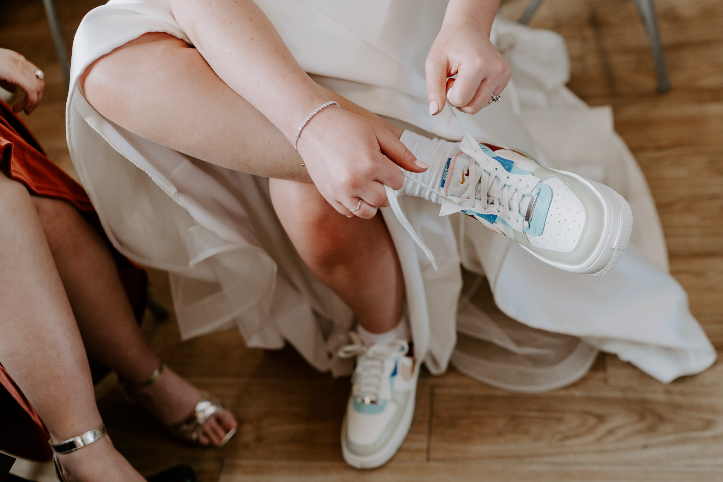 bride putting on wedding trainers 