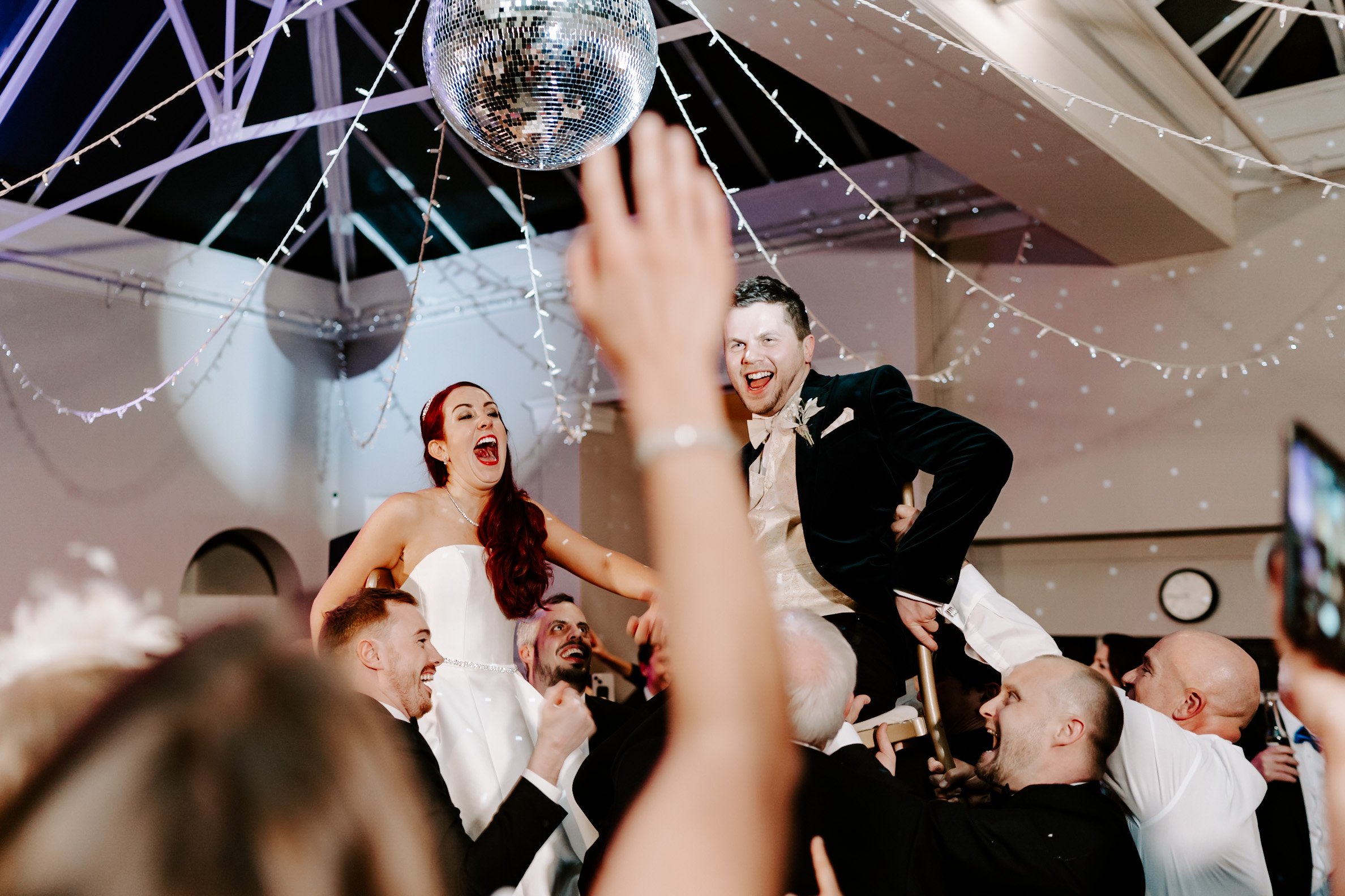 bride groom lifted in air on dance floor 