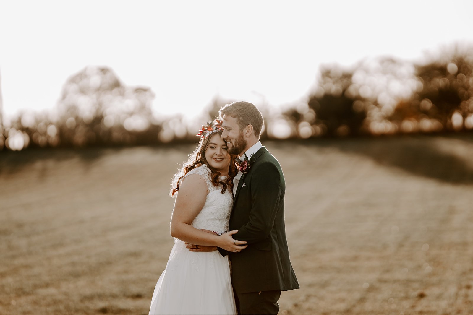 Old cow shed wedding couple hugging and laughing during golden hour