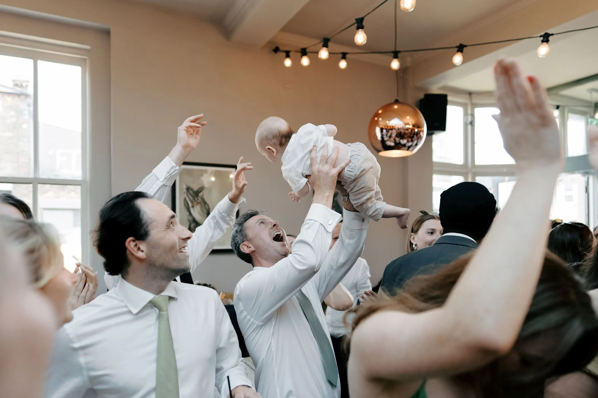 dad holding baby in air on dancefloor  | Gina Fernandes Photography