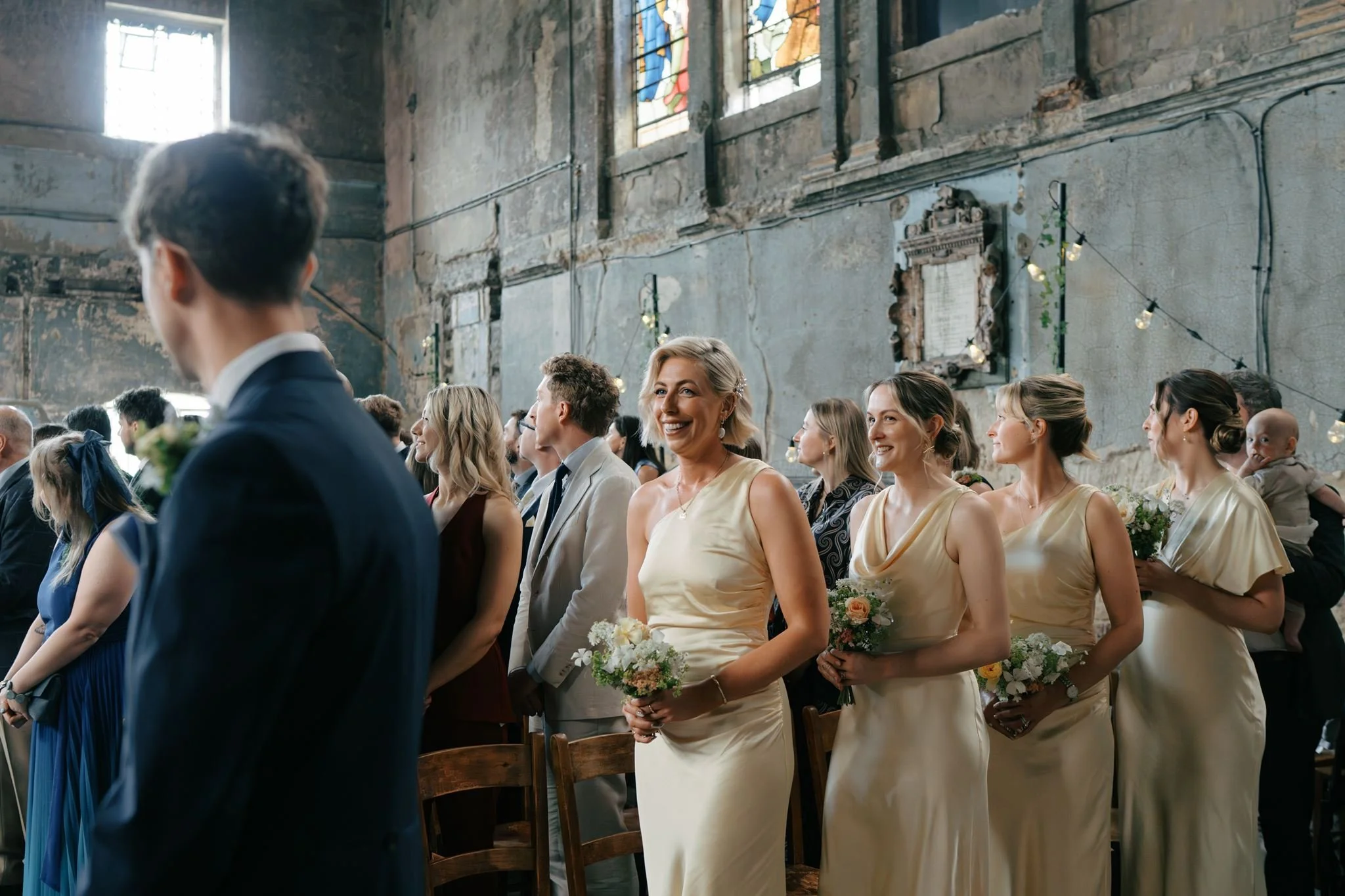 bridesmaids watching grooms reaction during wedding ceremony at Asylum Chapel London  | Gina Fernandes Photography
