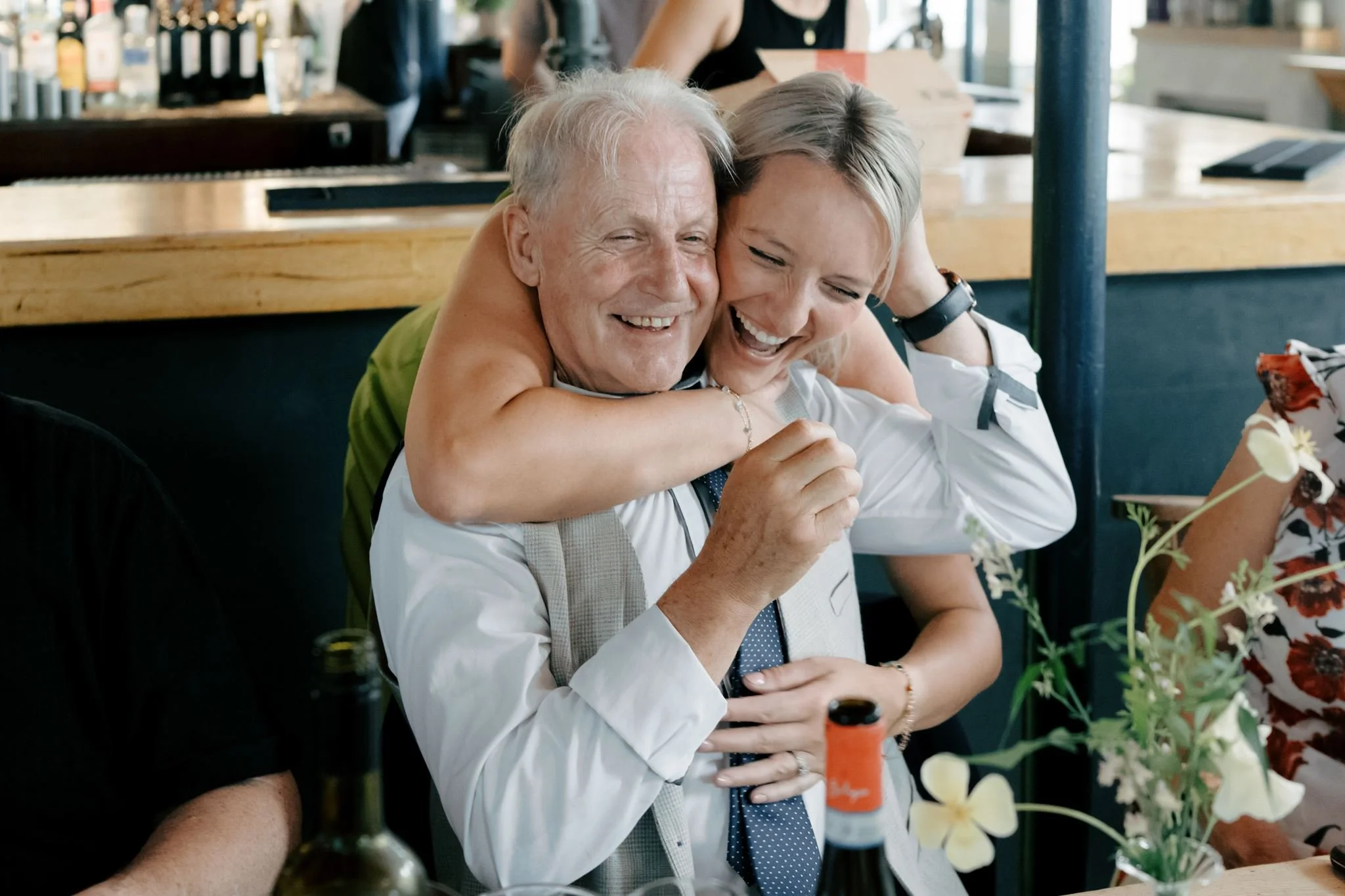 two wedding guests hugging and laughing  | Gina Fernandes Photography