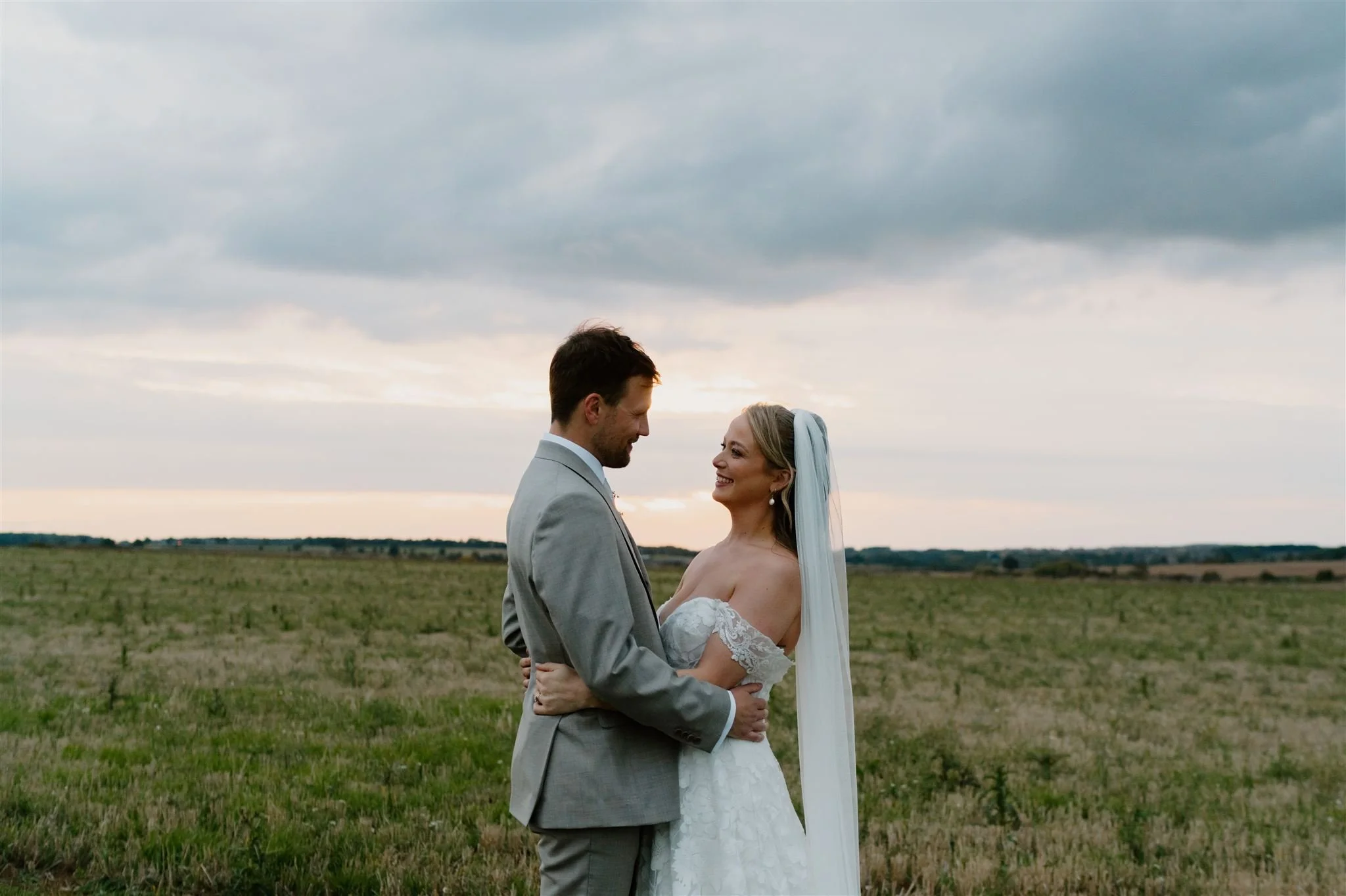Bride and groom sharing a quiet moment at sunset in the fields near Ed’s Hill Top sailcloth marquee in Stamford