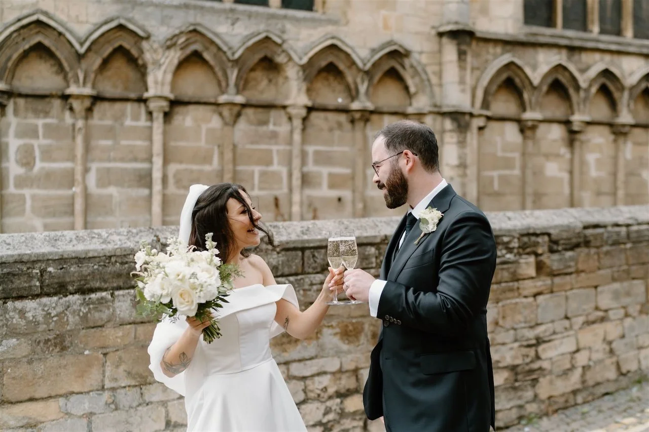 Bride and groom sharing a champagne toast outside a Stamford church after their wedding ceremony
