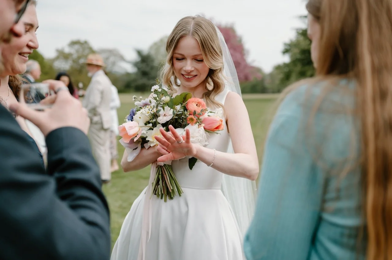 Bride showing her wedding ring to friends during the reception at Dunston Hall Estate.