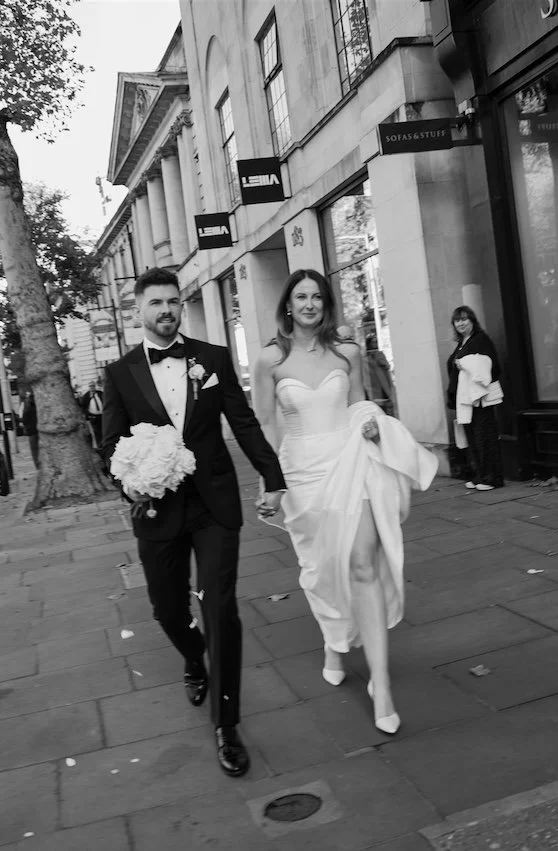 Bride and groom walking hand in hand through the streets of Chelsea after their London wedding ceremony