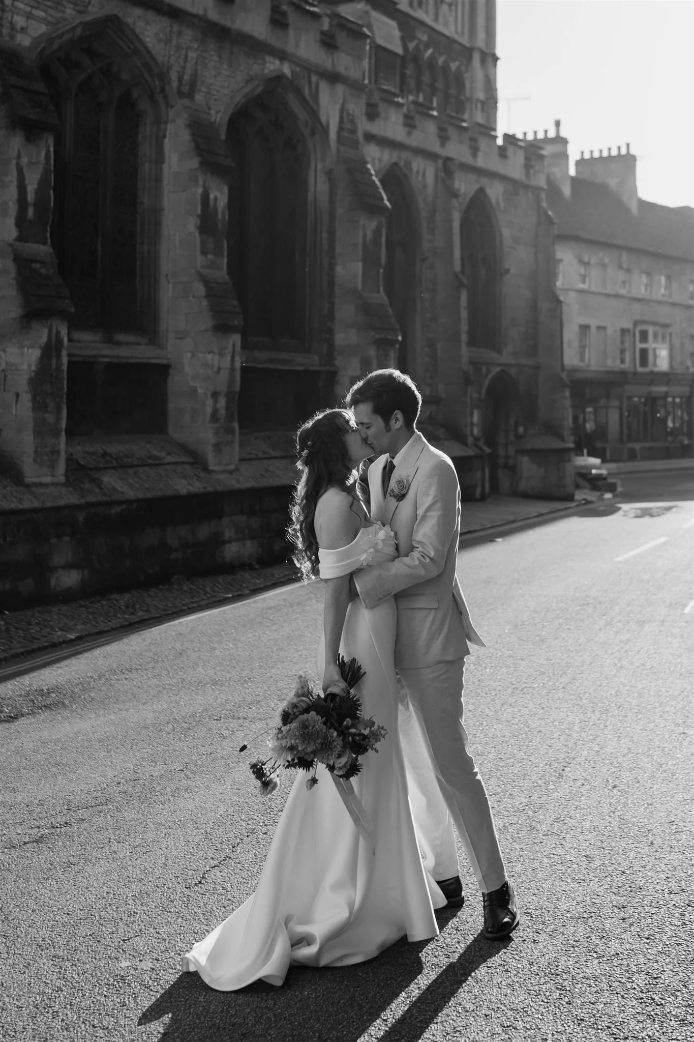 Black and white wedding portrait of a couple kissing in the street outside Stamford Town Hall.