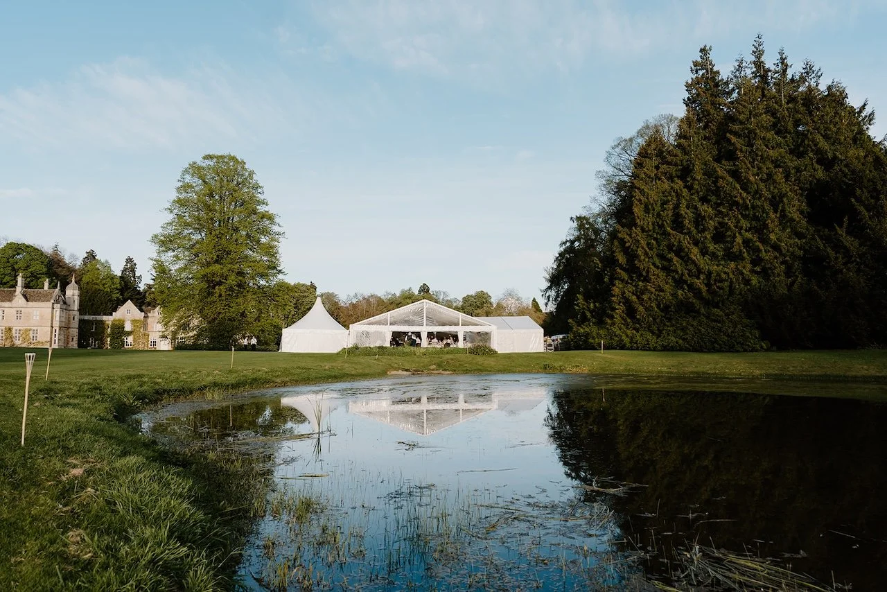 Marquee wedding reception reflected in the lake at Exton Park, Rutland.