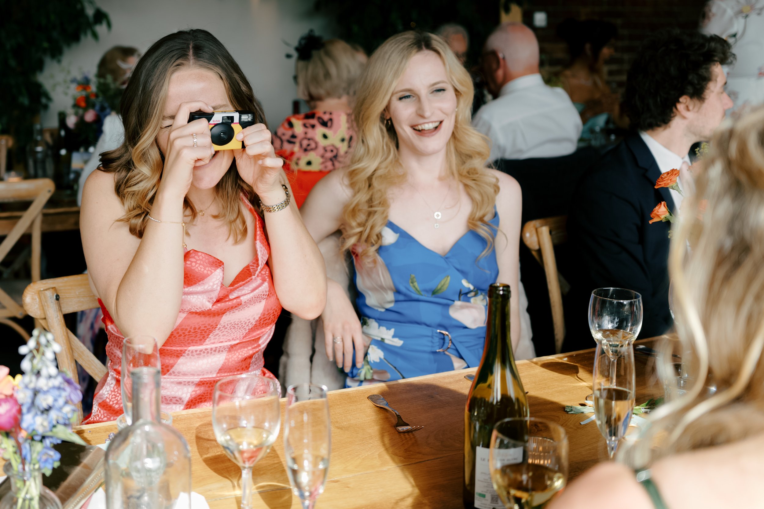 Guest holding a disposable camera at a wedding reception | Gina Fernandes Photography