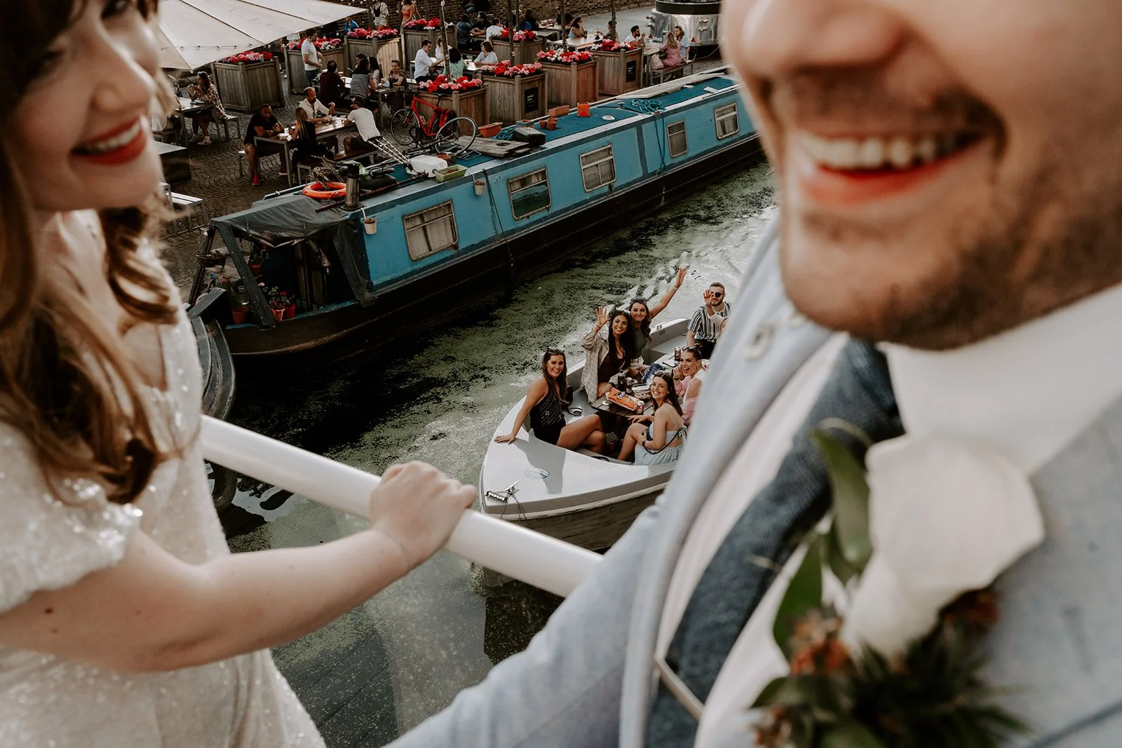 London town hall wedding couple on a bridge as a boat of friends waves up to them on the canal