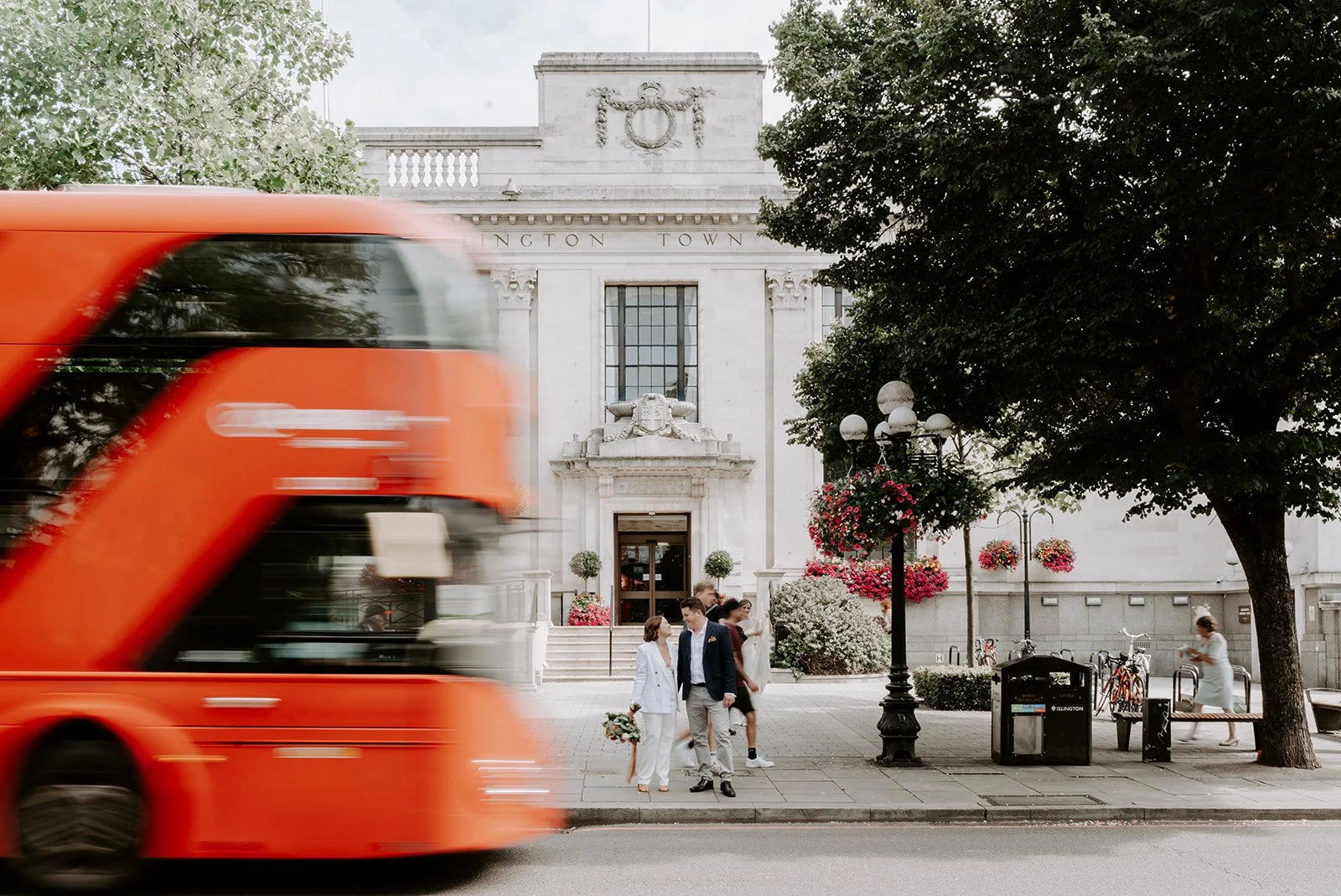 Couple outside Islington Town Hall as a red London bus passes, London town hall wedding photography