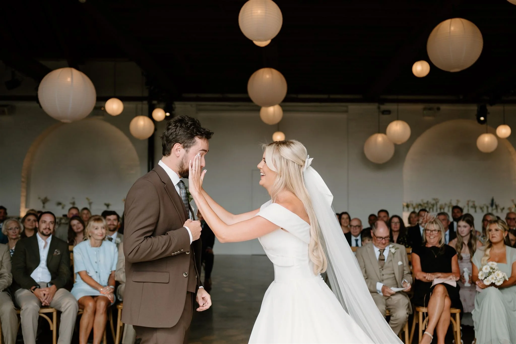 Bride wiping tears from groom’s face during wedding ceremony at Trinity Buoy Wharf