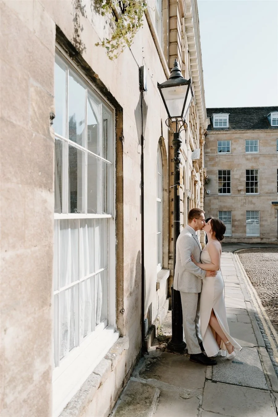 Bride and groom kissing on a cobbled street in Stamford after their wedding ceremony