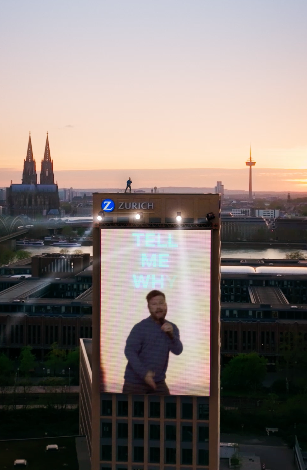 Ein Mann steht auf dem Gebäude der Zurich Versicherung und singt