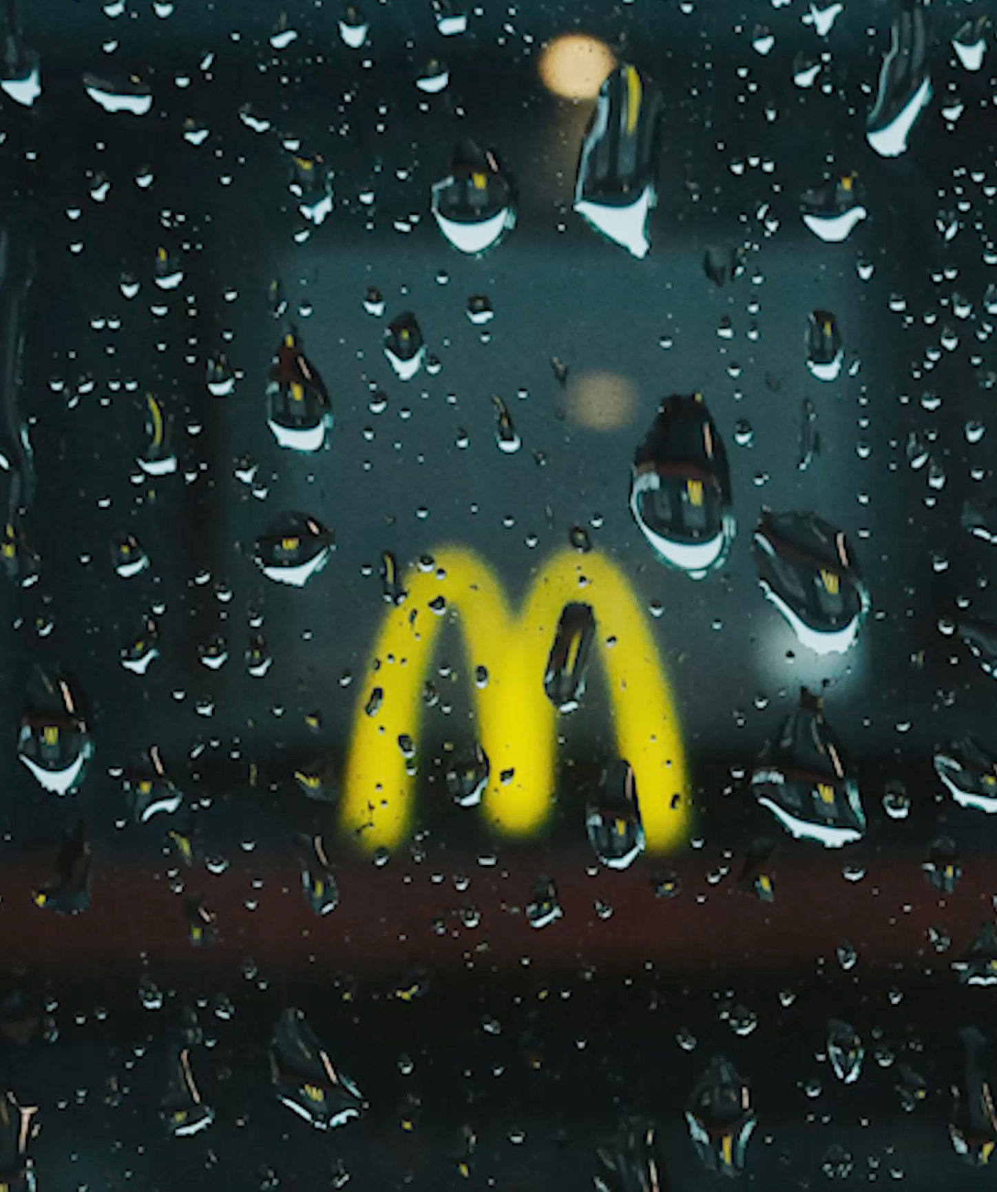 McDonalds Arches verschwommen hinter einer verregneten Scheibe