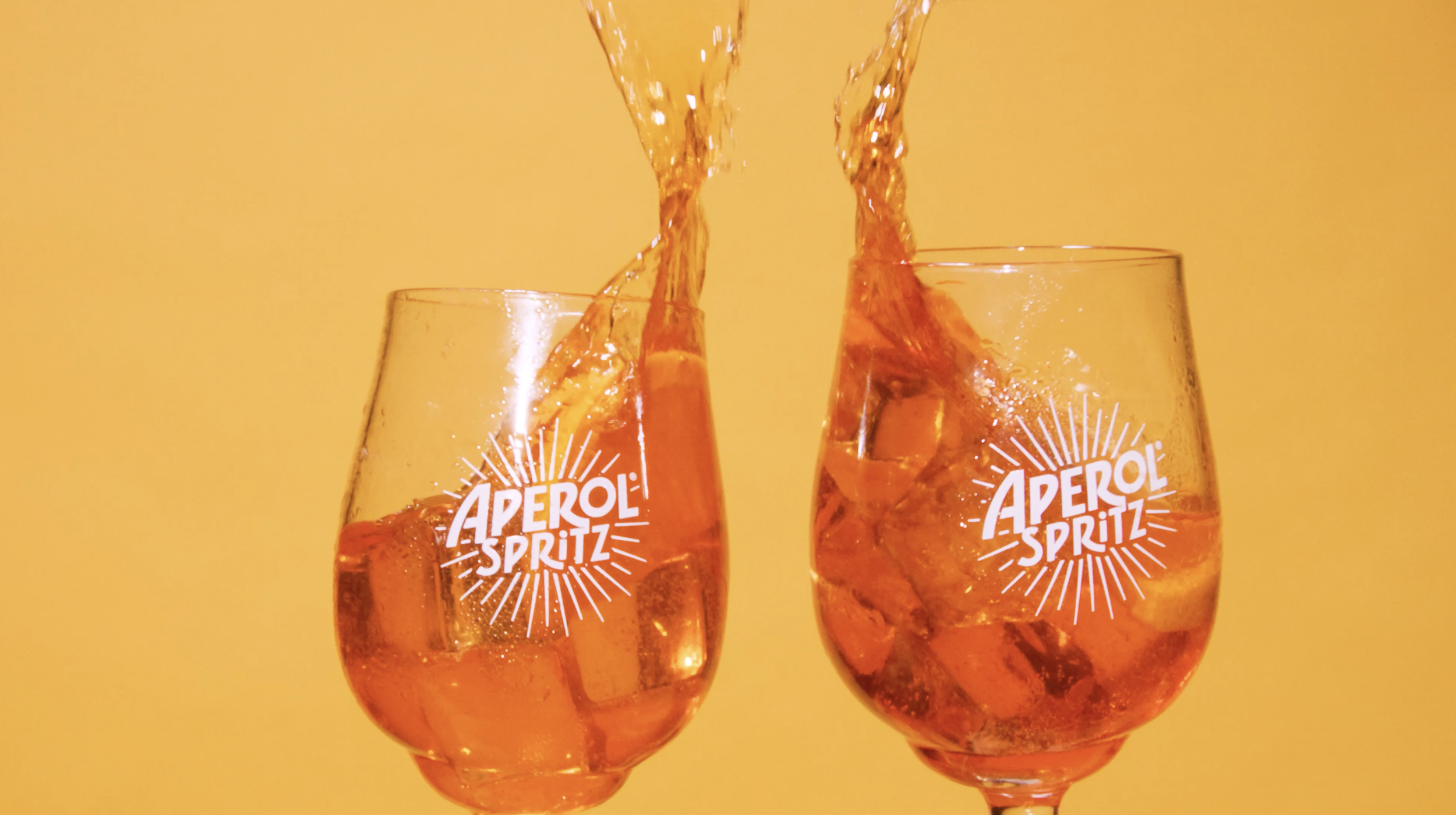 In einem von Get Flashed Media produzierten Produktvideo spritzt Aperol aus zwei Gläsern