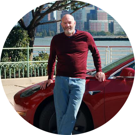 Mike standing in front of his Tesla