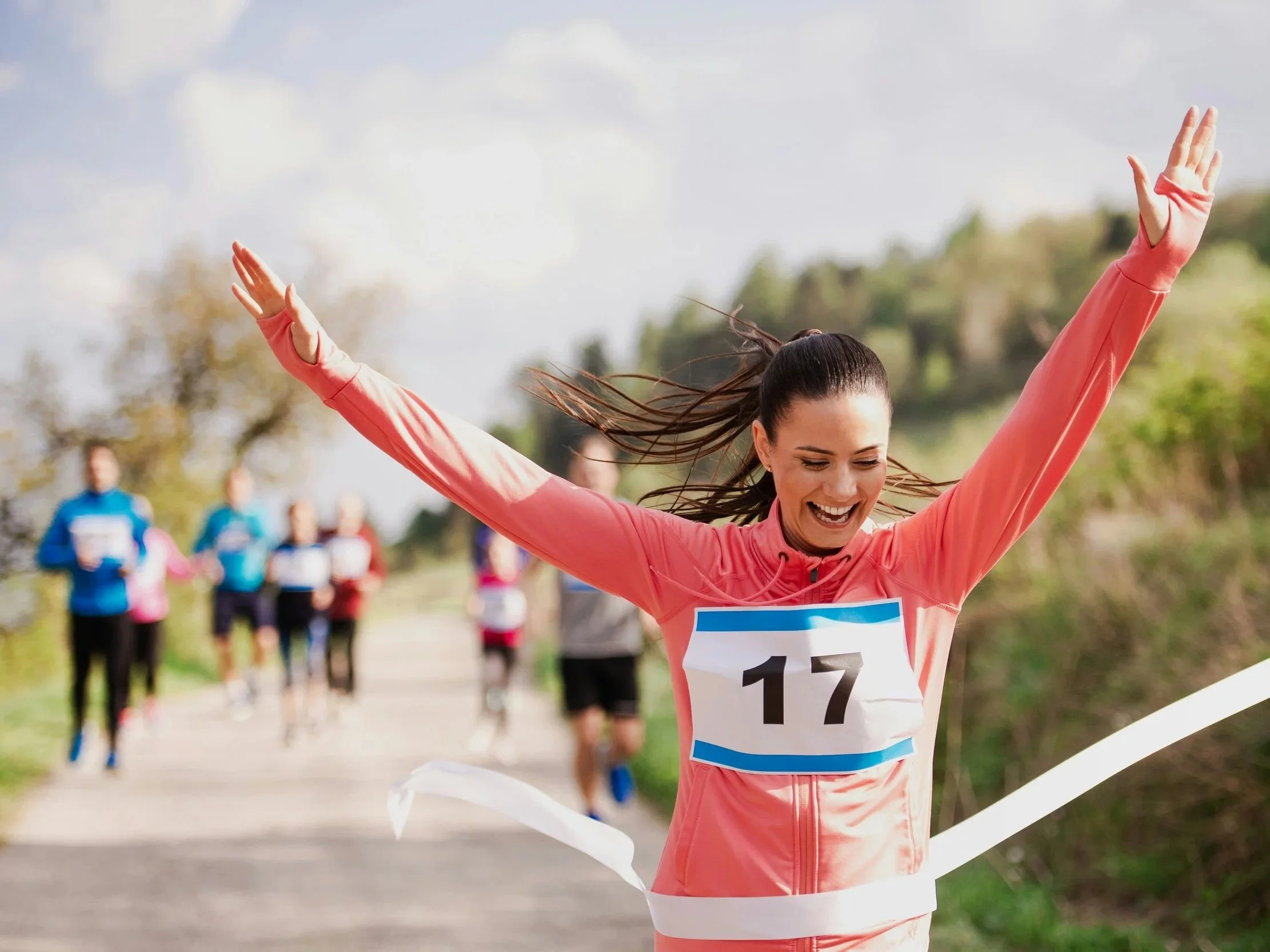 A woman crosses the finish line while running a marathon