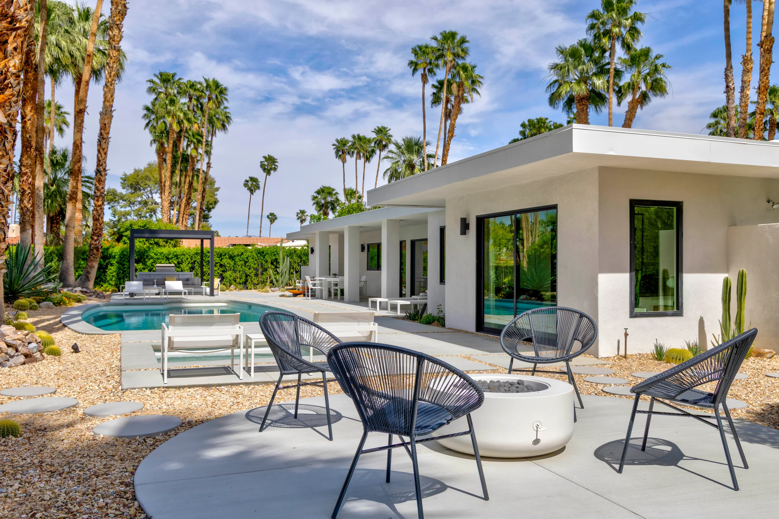 Modern desert home in Palm Springs with poolside landscape design, clean concrete hardscape, and seamless indoor-outdoor living.