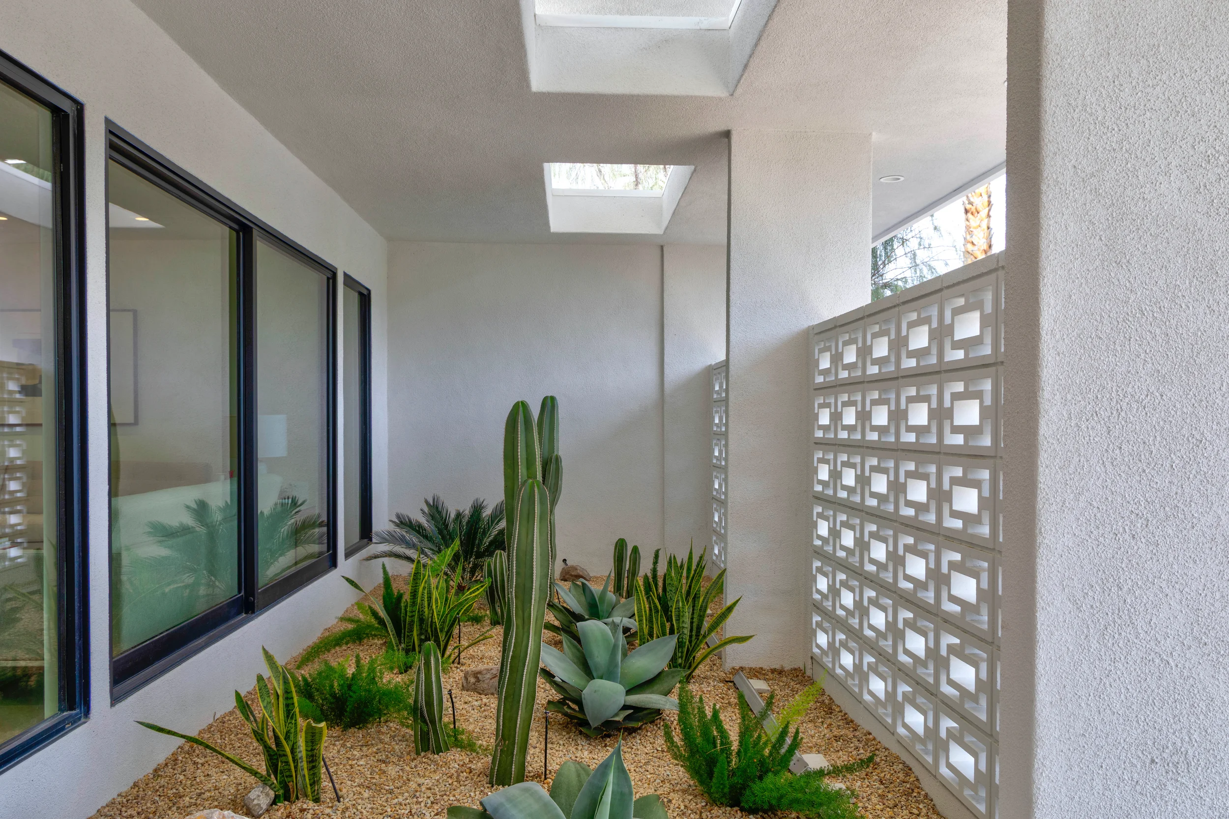 Palm Springs modern desert courtyard with agave, cactus, gravel landscape, and breeze block screening in Indian Canyons.