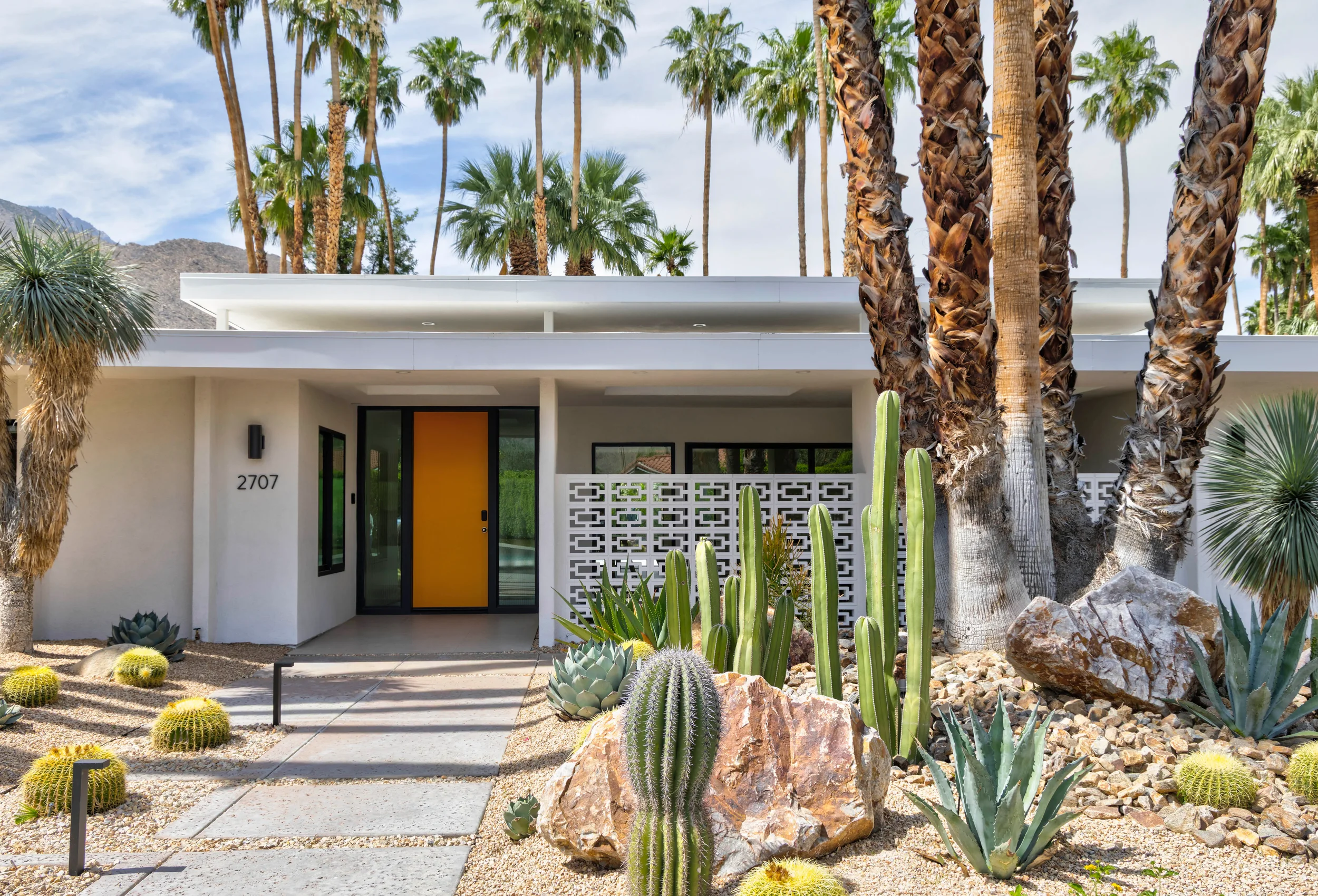 Palm Springs modern desert landscape front entry with sculptural cacti, boulders, and concrete walkway in Indian Canyons.