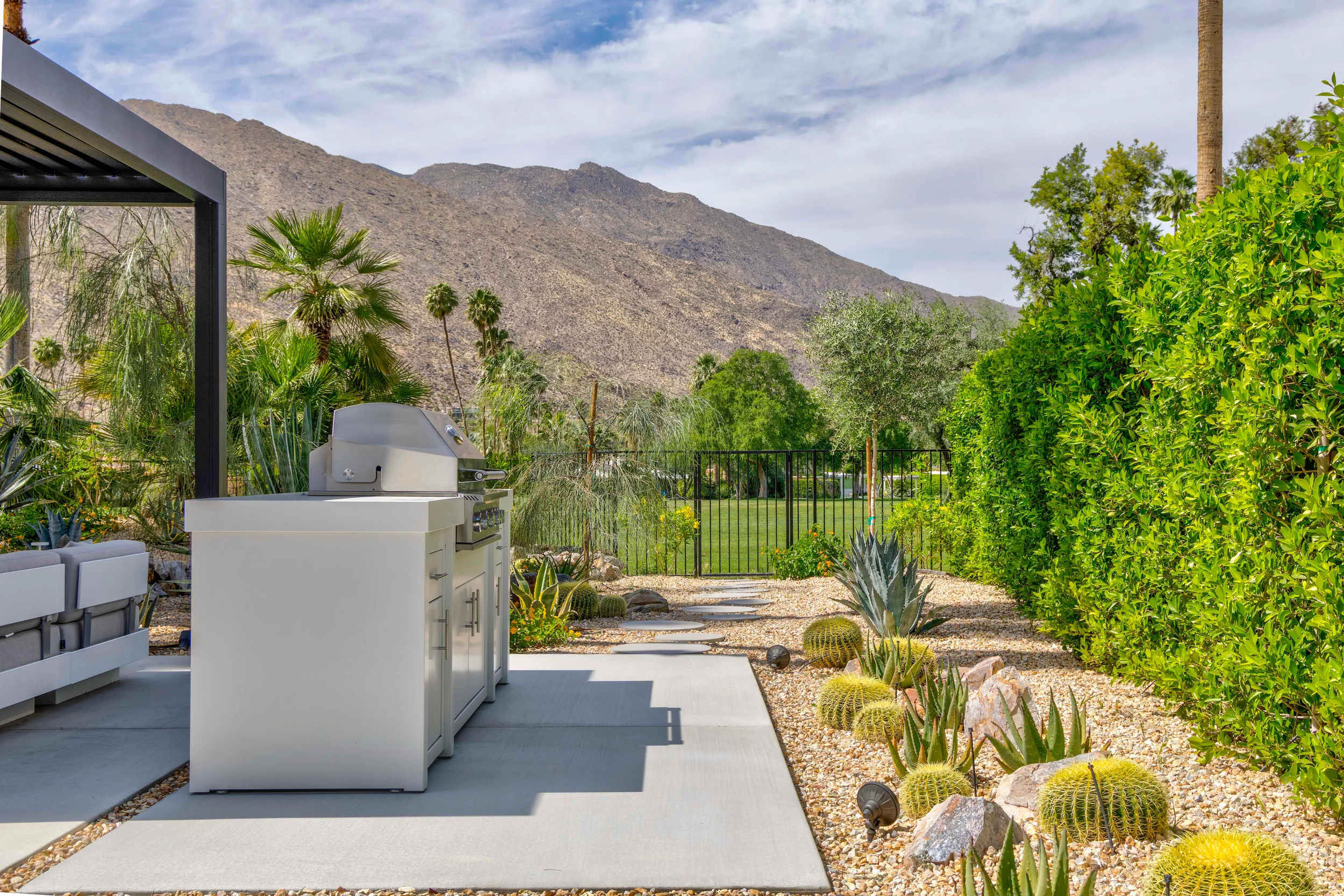 Palm Springs modern desert outdoor kitchen with grill, concrete patio, and cactus planting in Indian Canyons with mountain views.