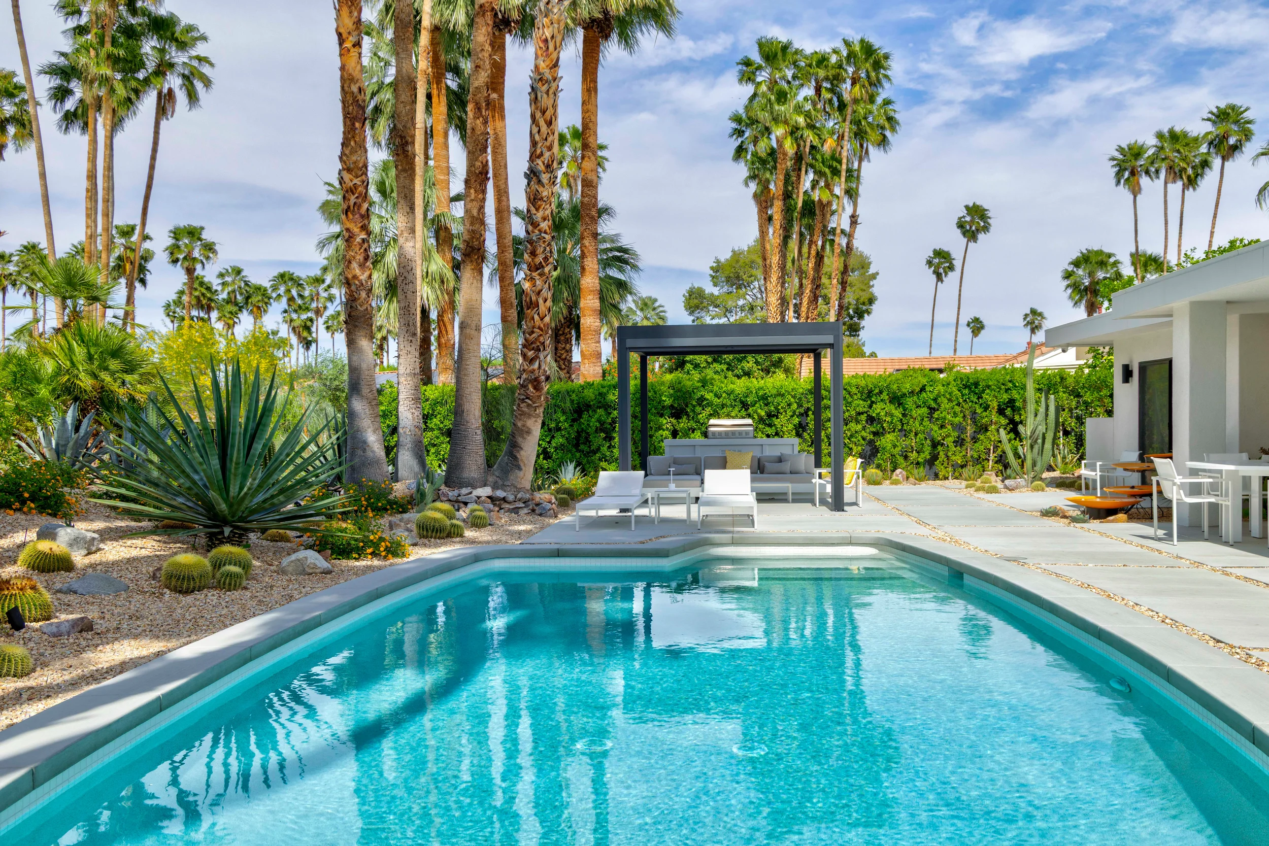 Palm Springs modern desert pool with pergola lounge, concrete decking, and drought-tolerant planting in Indian Canyons.