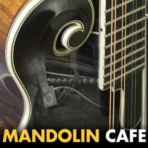 Close-up of a black and white mandolin guitar with the text 'Mandolin Cafe' in yellow and white at the bottom.