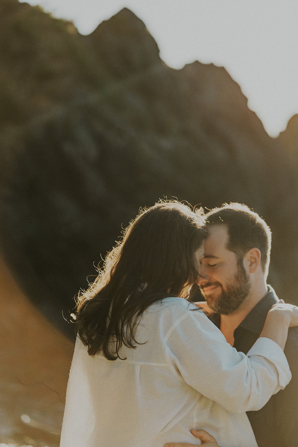 couple holding hands at deception pass state park along rocky coastline