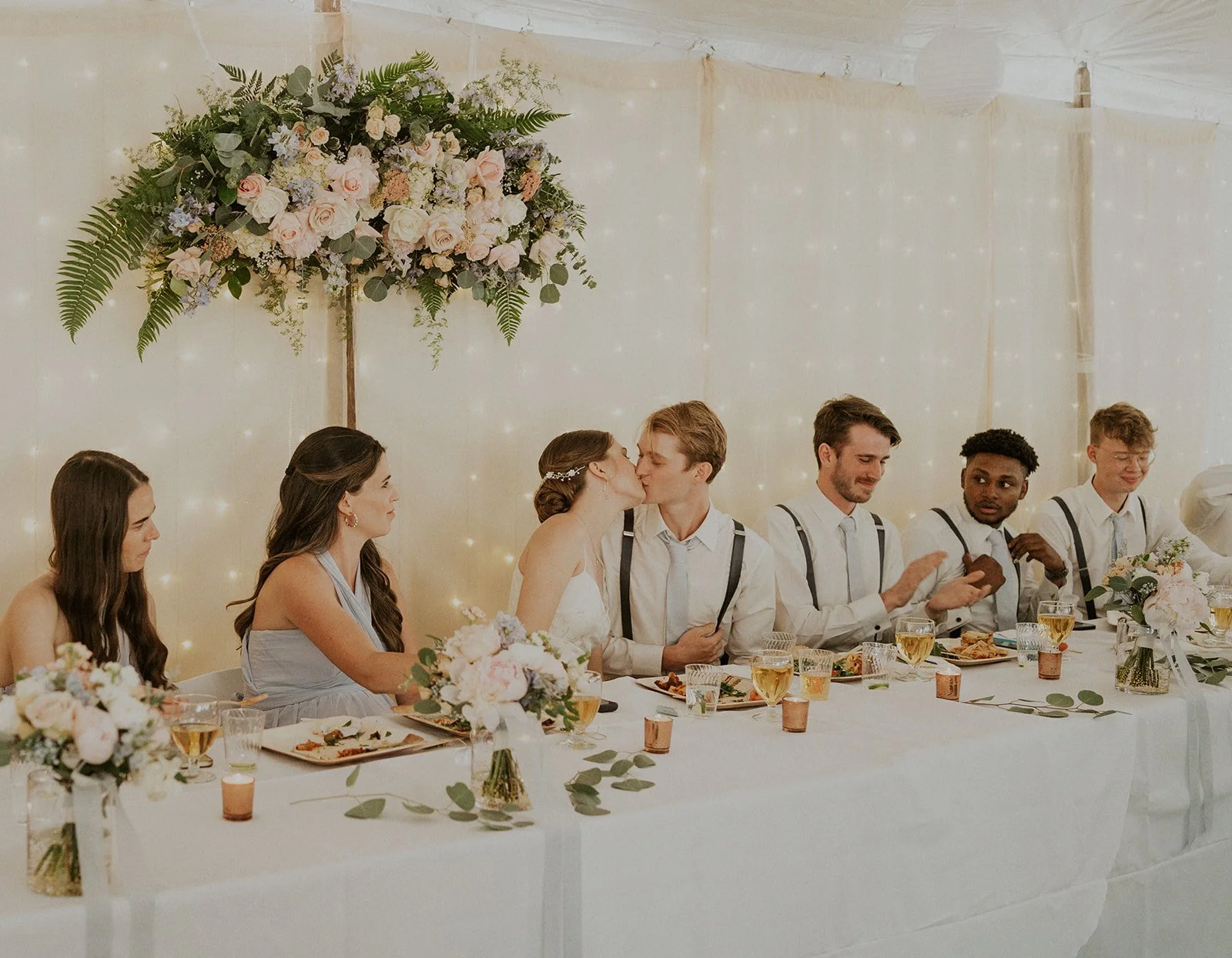 bride and groom kissing at reception table