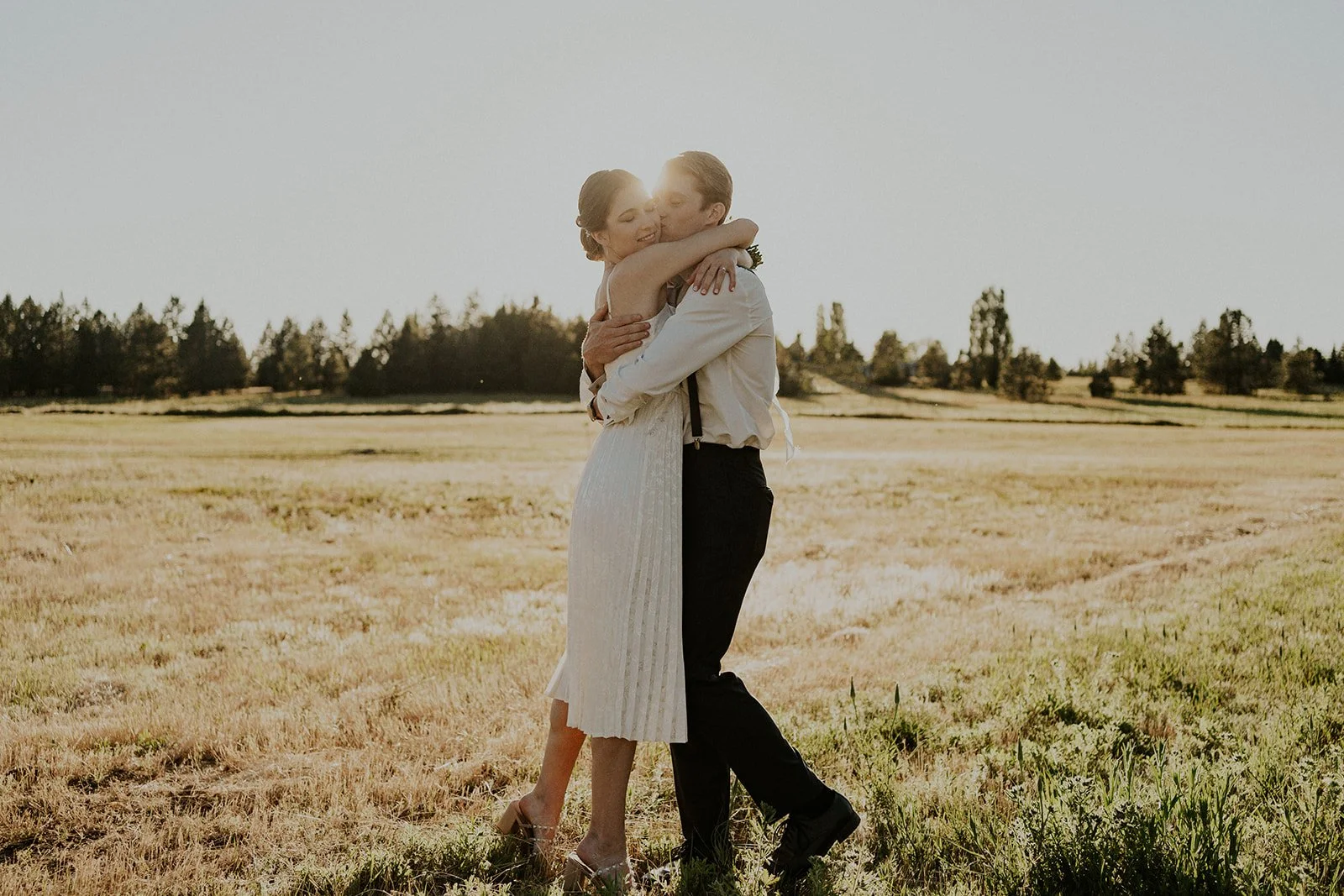 bride and groom hugging at sunset in spokane field