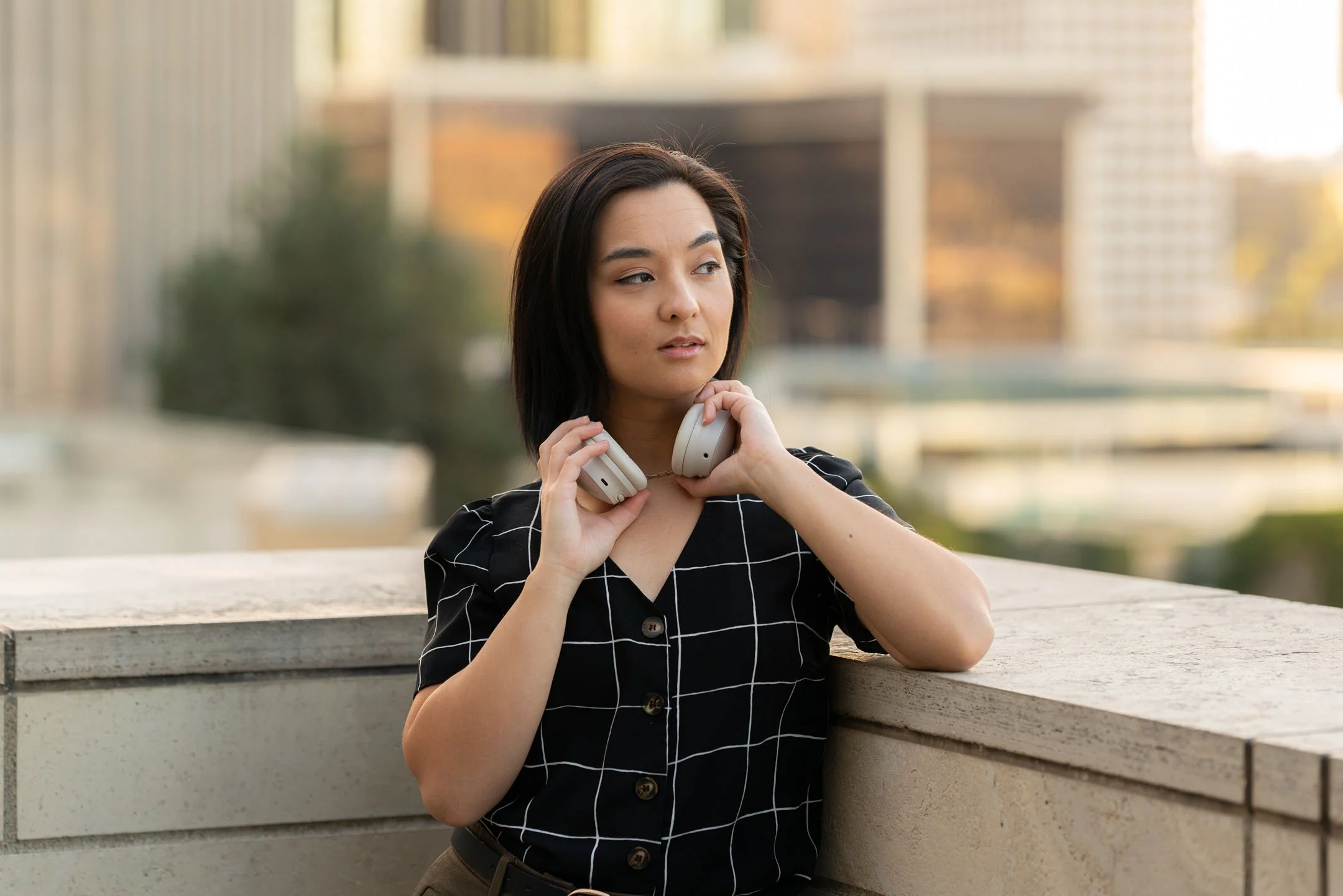 Los Angeles model putting on white Bose headphones at Downtown LA