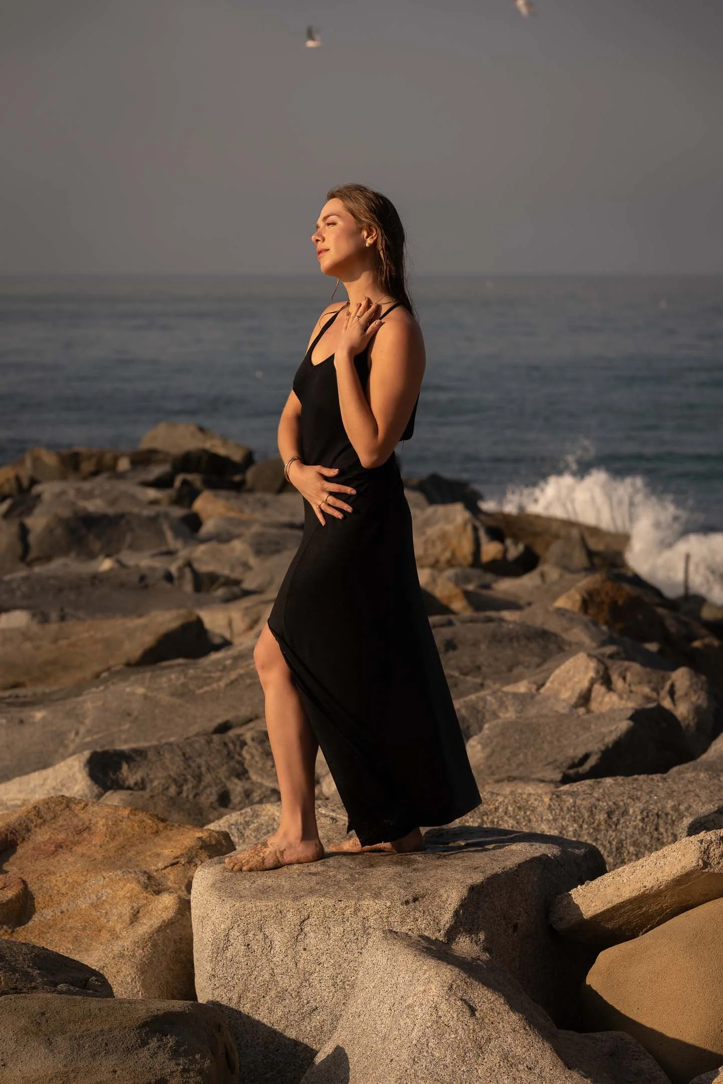 Fashion model posing on the rocks at Santa Monica during sunrise
