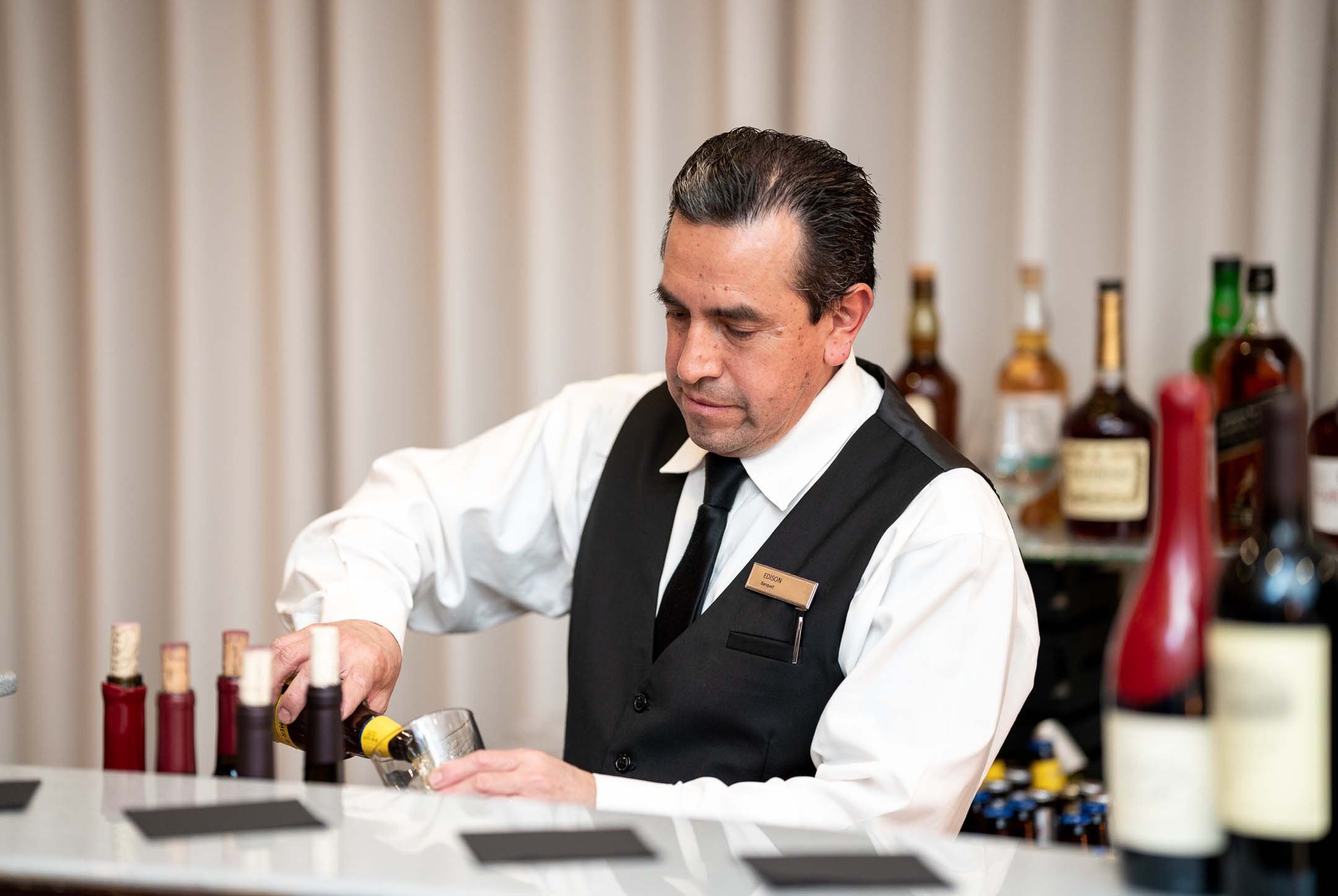 Bartender pouring drink at the bar in Hilton Santa Monica hotel